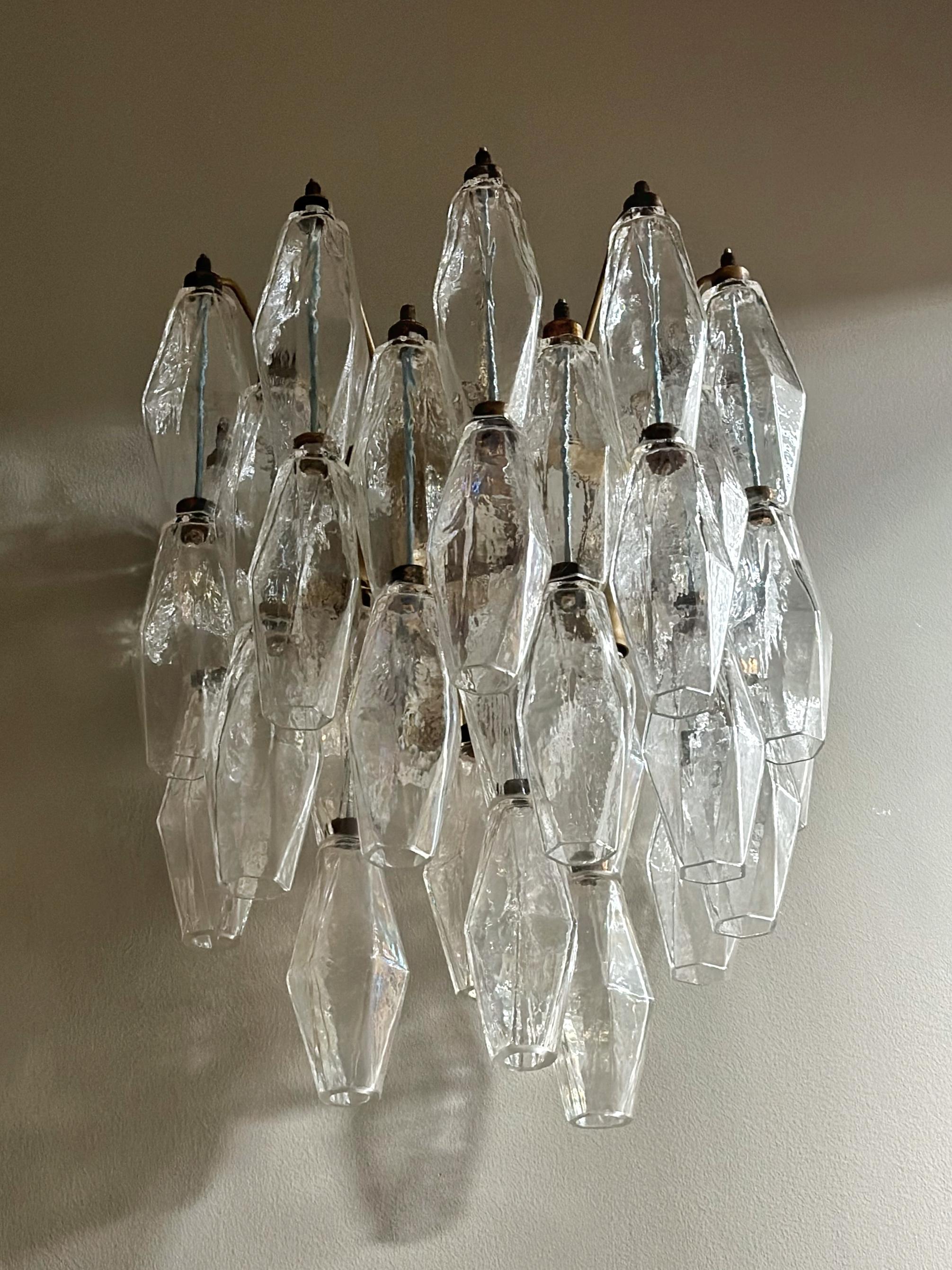 Pair of Murano Wall Lamps consisting of 33 handmade crystal prisms in clear murano glass. Lamp structure of metal with fittings painted in a light brown, bronzy tone. Glass from the Italian Murano District. Traditional Italian Mid-Century Style.

3