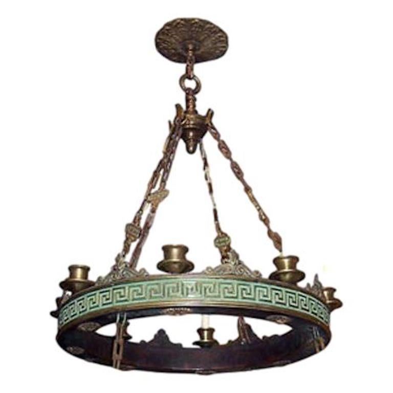 Pair of English neoclassic style cast bronze eight-light chandeliers with Greek key motif, rectangular cast chains, original oversized canopy and rosettes on the bottom of the body. 

Measurements:
Drop 32