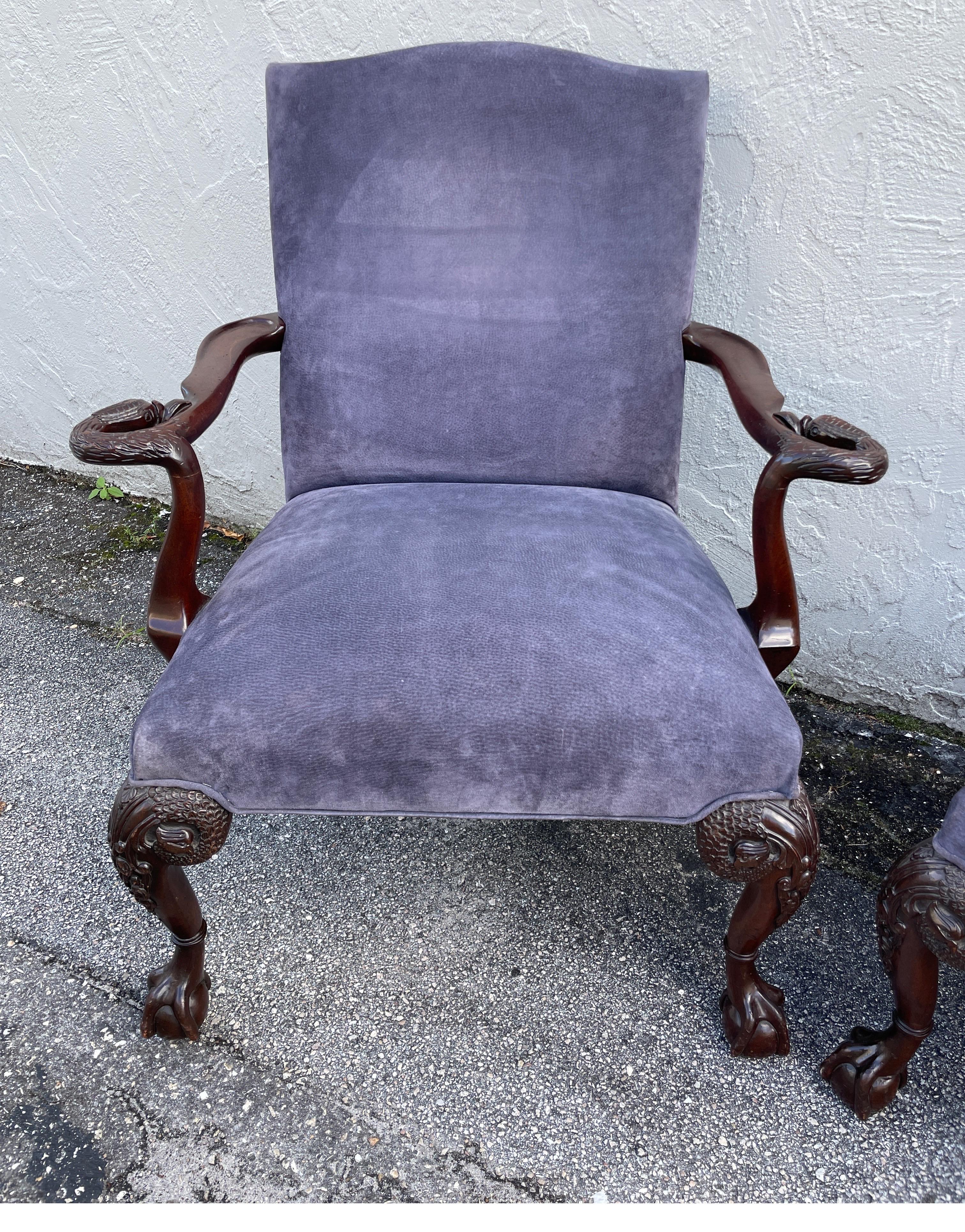 Paire de fauteuils majestueux recouverts de daim bleu marine avec des accoudoirs sculptés en forme de tête de cygne.
Les pieds avant ont un pied sculpté en forme de boule et de griffe.