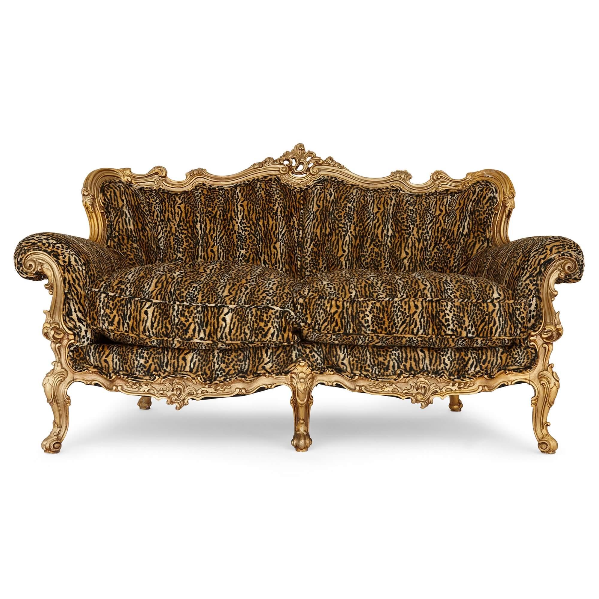 Paire de grands canapés anciens en bois doré.
Français, début du 20e siècle.
Mesures : Hauteur 100 cm, largeur 148 cm, profondeur 75 cm.

Tapissés de peau de léopard, ces canapés remarquablement somptueux, luxueux et ornés sont fabriqués en bois