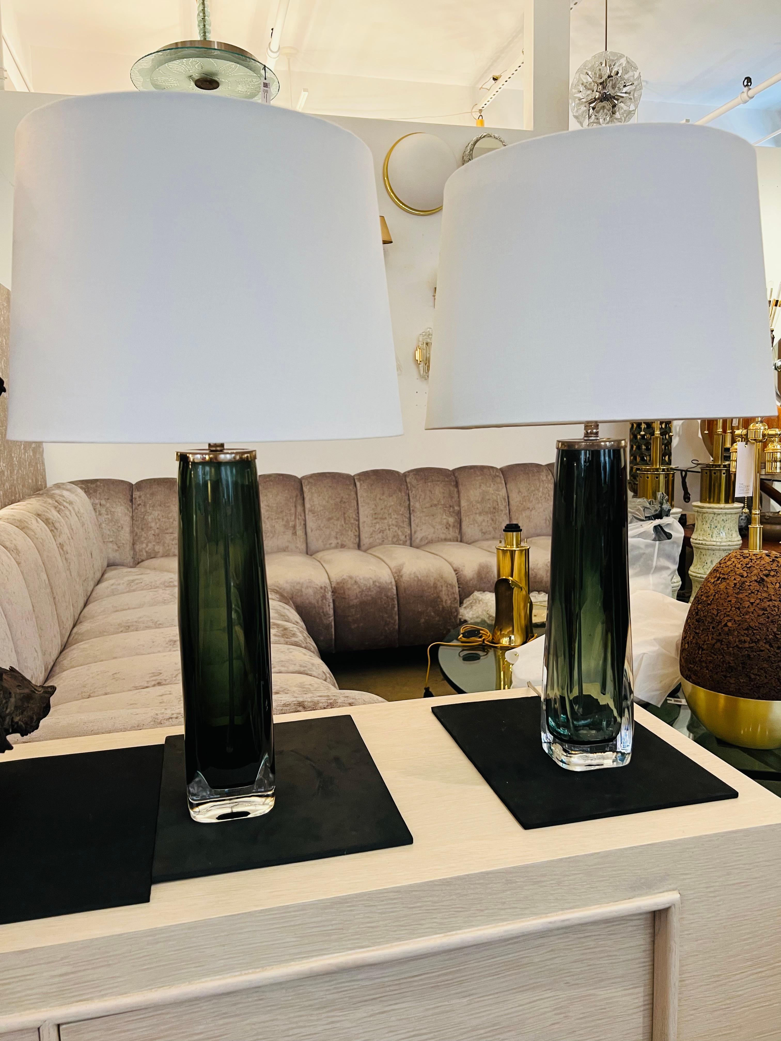 Pair of beautiful large dark green crystal table lamps with new polished nickel double cluster sockets Ny Carl Fagerlund for Orrefors.
Original label. 
Newly rewired with two standard sockets each.