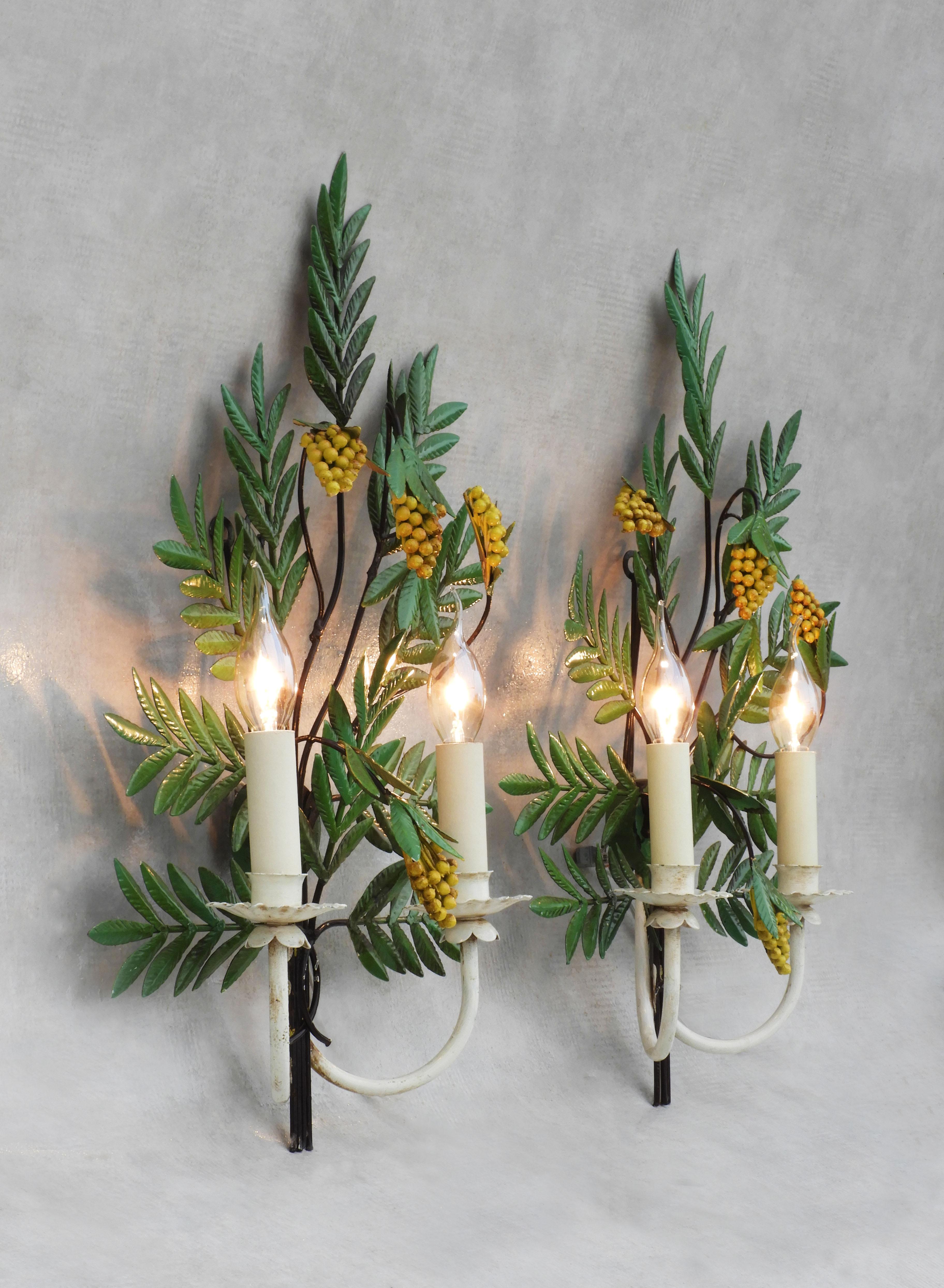 Charming pair of French botanical-themed wall light sconces. 
A delightful duo of large hand-painted toleware bouquets made up of bright yellow flowering fruits and branches of green glossy foliage each with two ‘faux’ candle lights. In good vintage