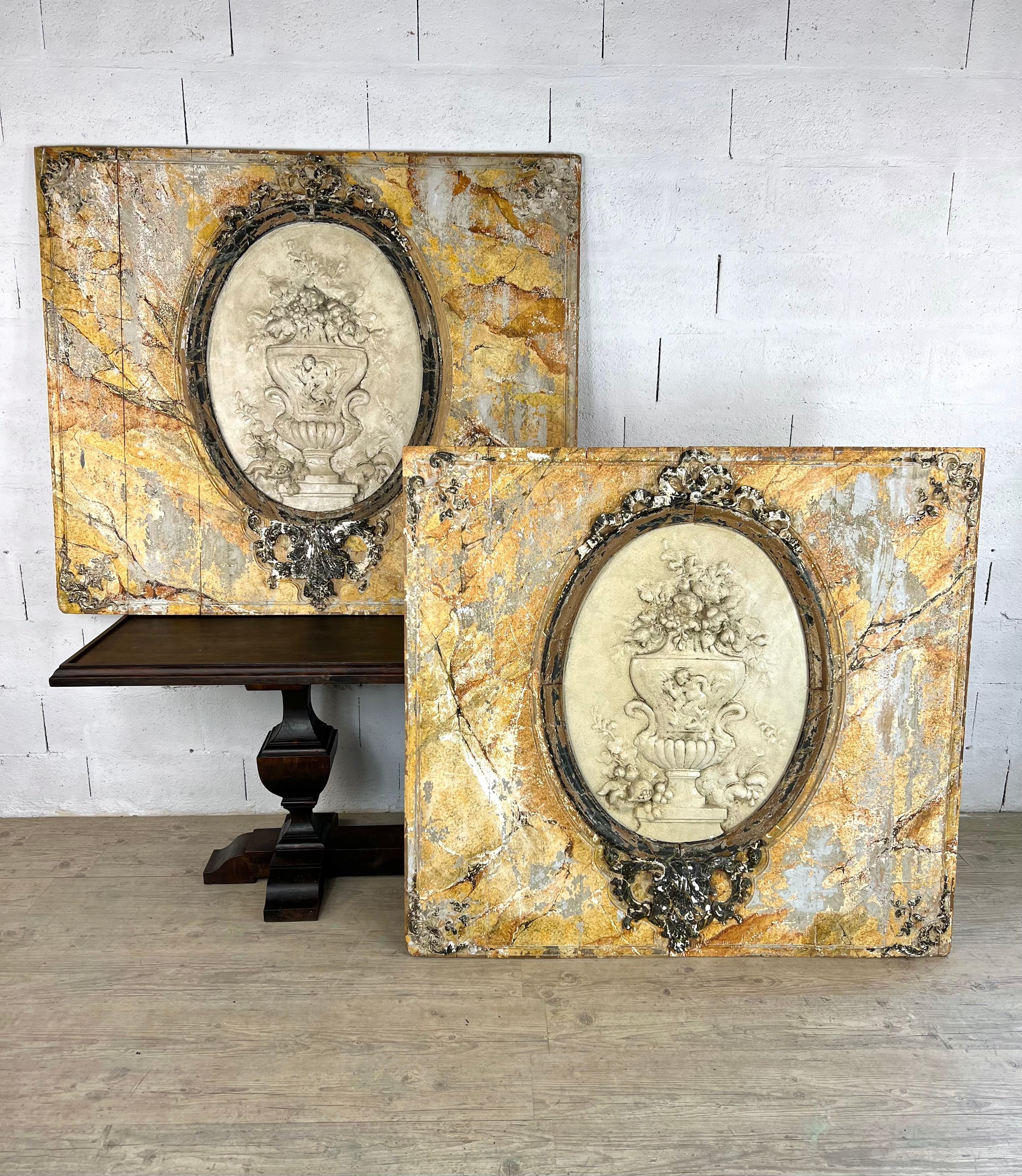 Cette paire de grands panneaux en bois peint incarne magnifiquement l'élégance et la richesse ornementale du design rococo italien. La finition ocre en faux marbre apporte chaleur et sophistication, tandis que les médaillons ovales en plâtre, ornés