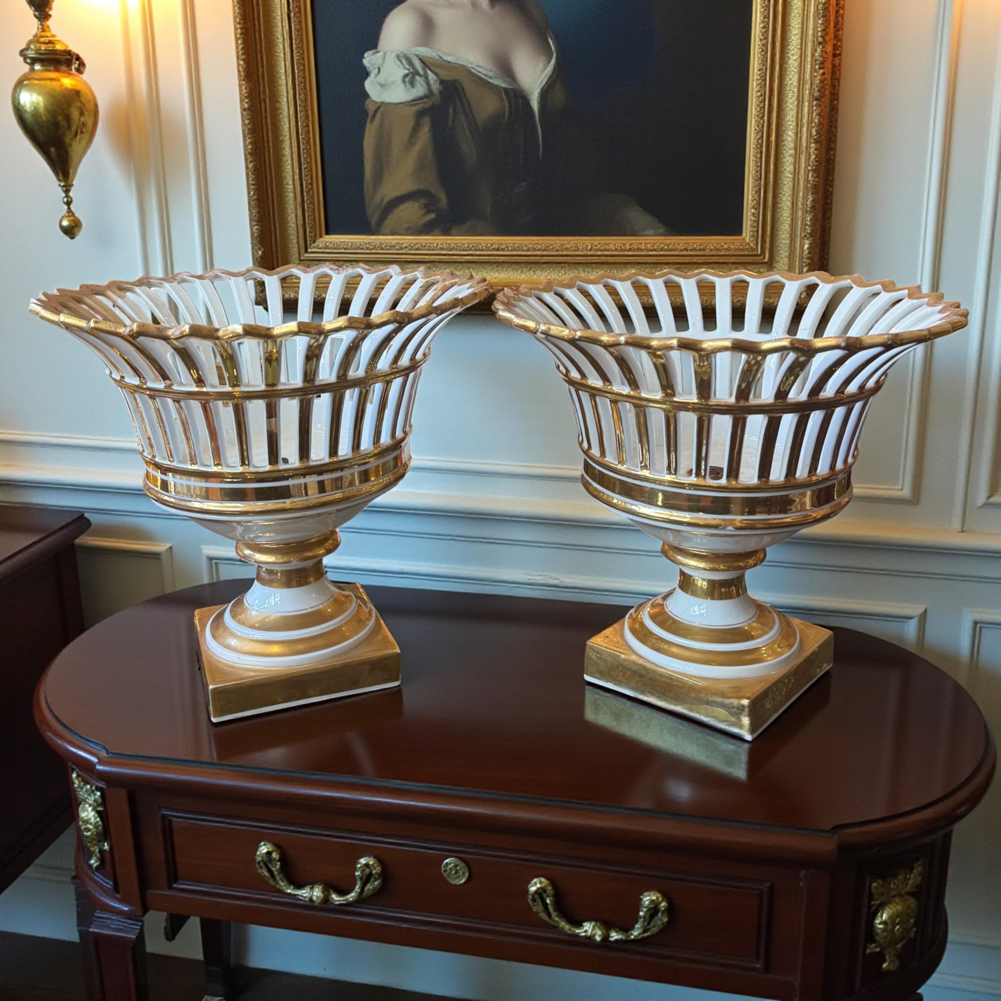 Eccezionale coppia di centrotavola in porcellana parigina traforata, riccamente impreziositi da decorazioni in oro. Risalenti al periodo della Restaurazione - Charles X (circa 1820-1830), questi pezzi esemplificano la raffinata maestria degli