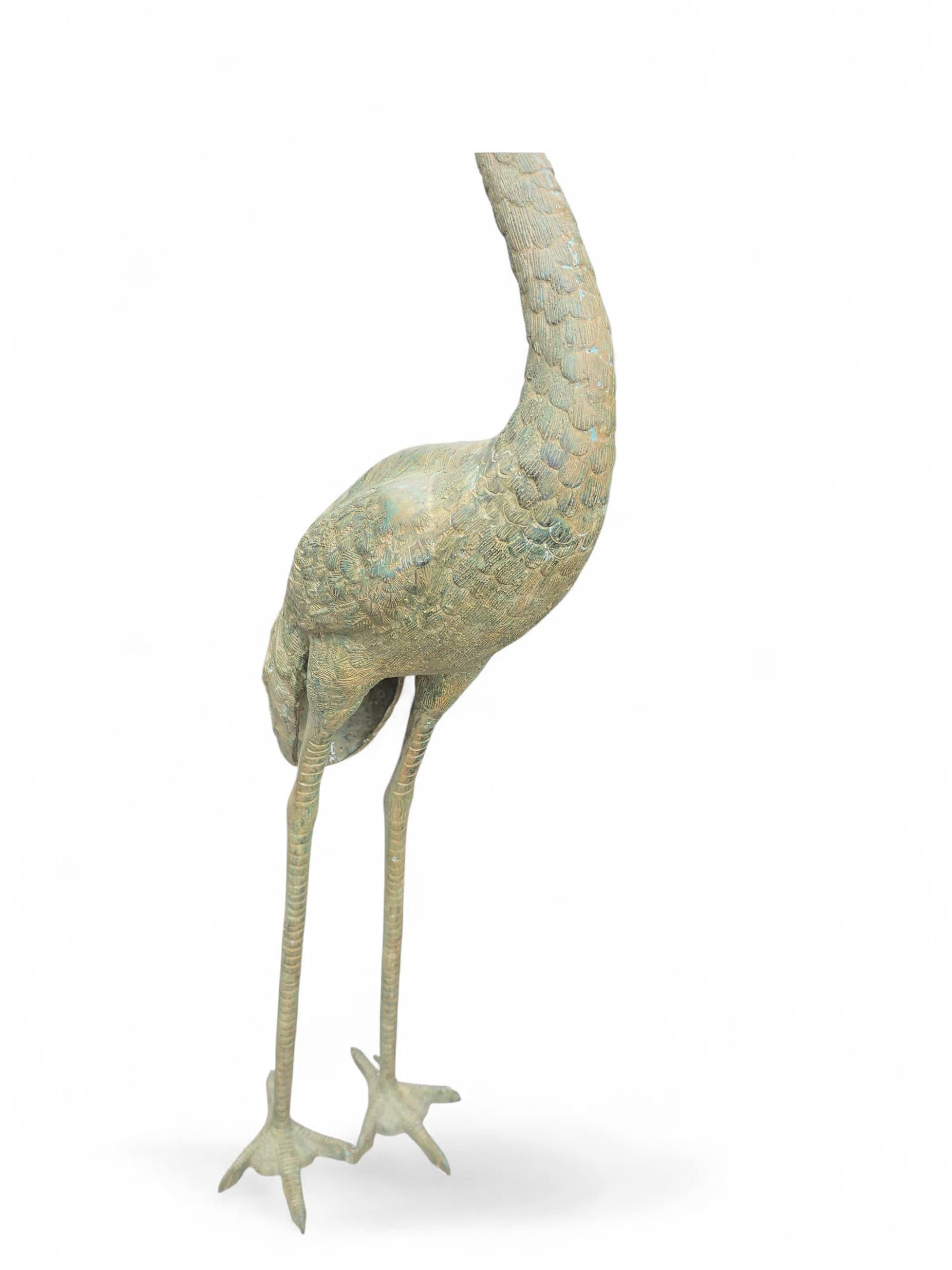 Elegante coppia di grandi sculture di aironi in bronzo patinato con una ricca finitura verde, risalenti al XX secolo. Ogni uccello è reso con una postura aggraziata e un alto livello di dettaglio nelle piume, nelle zampe e nei tratti del viso,