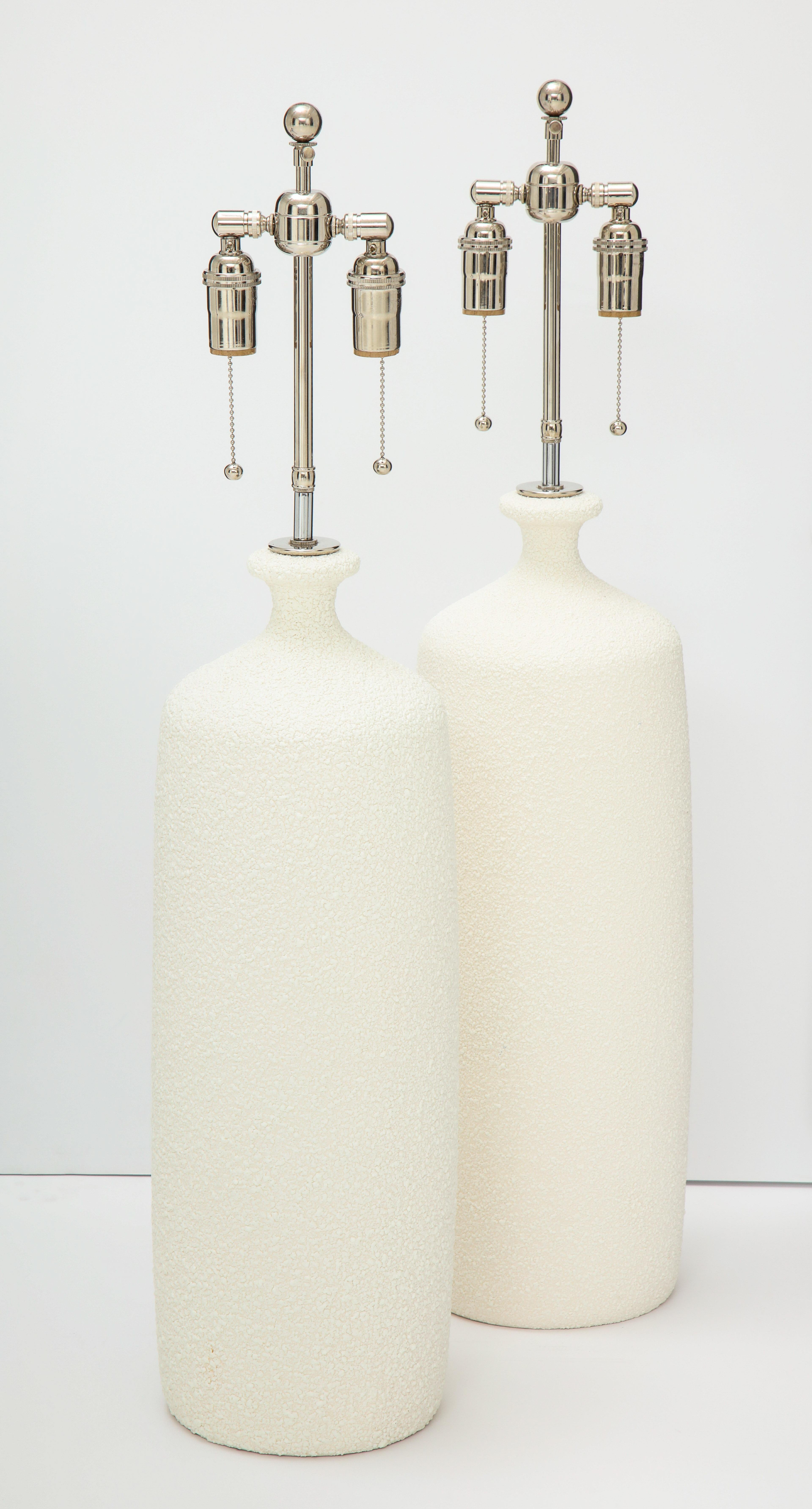 Pair of large 1970s ceramic lamps with a popcorn textured finish.
The lamps have been newly rewired with polished nickel double clusters.