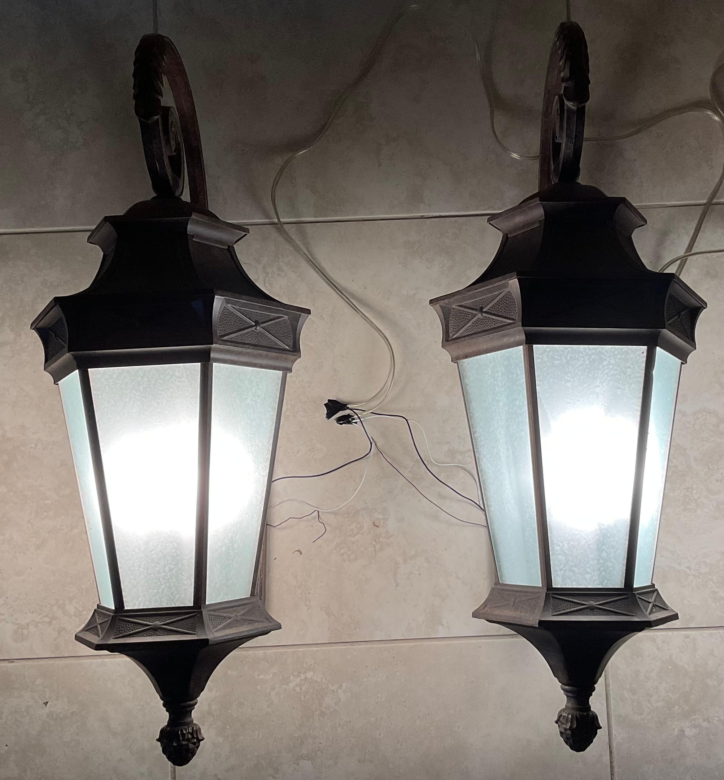 An elegant outdoor pair of lighting  in the neoclassic style into a contemporary structure ,made of power coated aluminium, decorative acrylic glass like sides , ample light exposure of four 60/watt lights  ,great detailed craftsmanship . 
Up to US