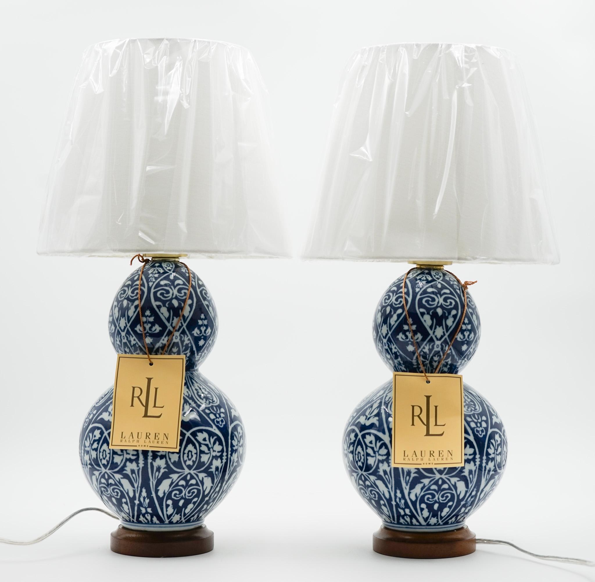 Antiquités de Londres

Paire de lampes de table sophistiquées en céramique bleue et blanche de Lauren Ralph Lauren, présentant un motif floral complexe et une élégante base en bois avec des détails en laiton. Chaque lampe comprend son étiquette