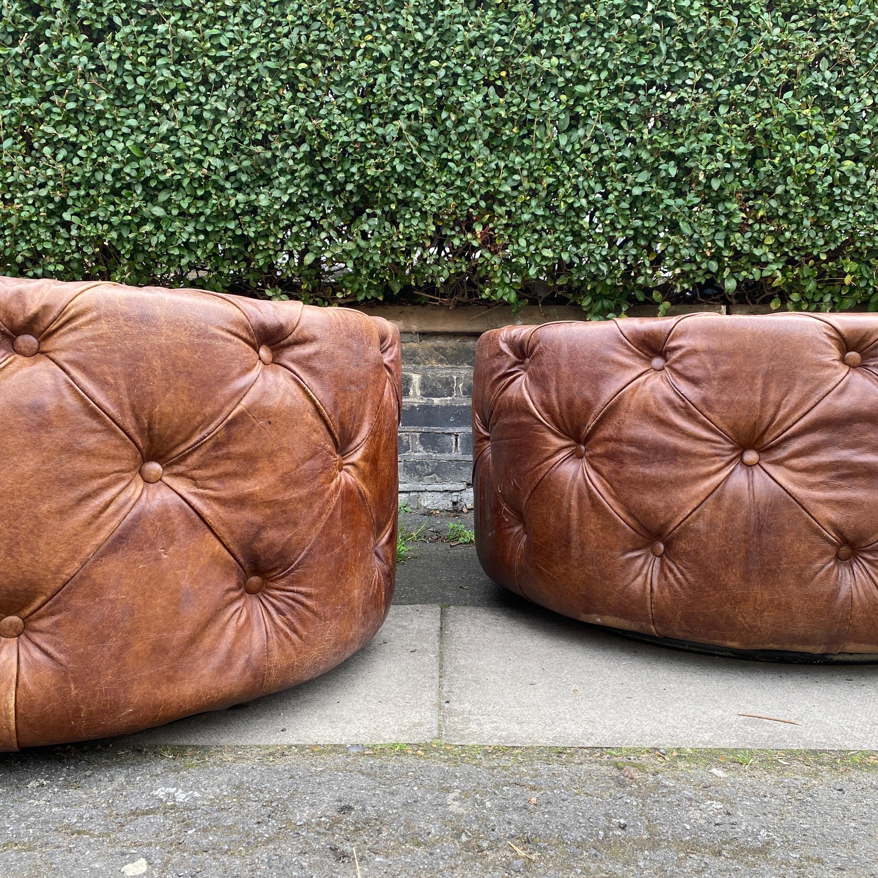 Introducing a pair of exquisite Large Round Leather Rotating Buttoned Ottomans, a delightful combination of elegance and functionality. With two of these unique pieces available, you have the opportunity to transform your living space into a