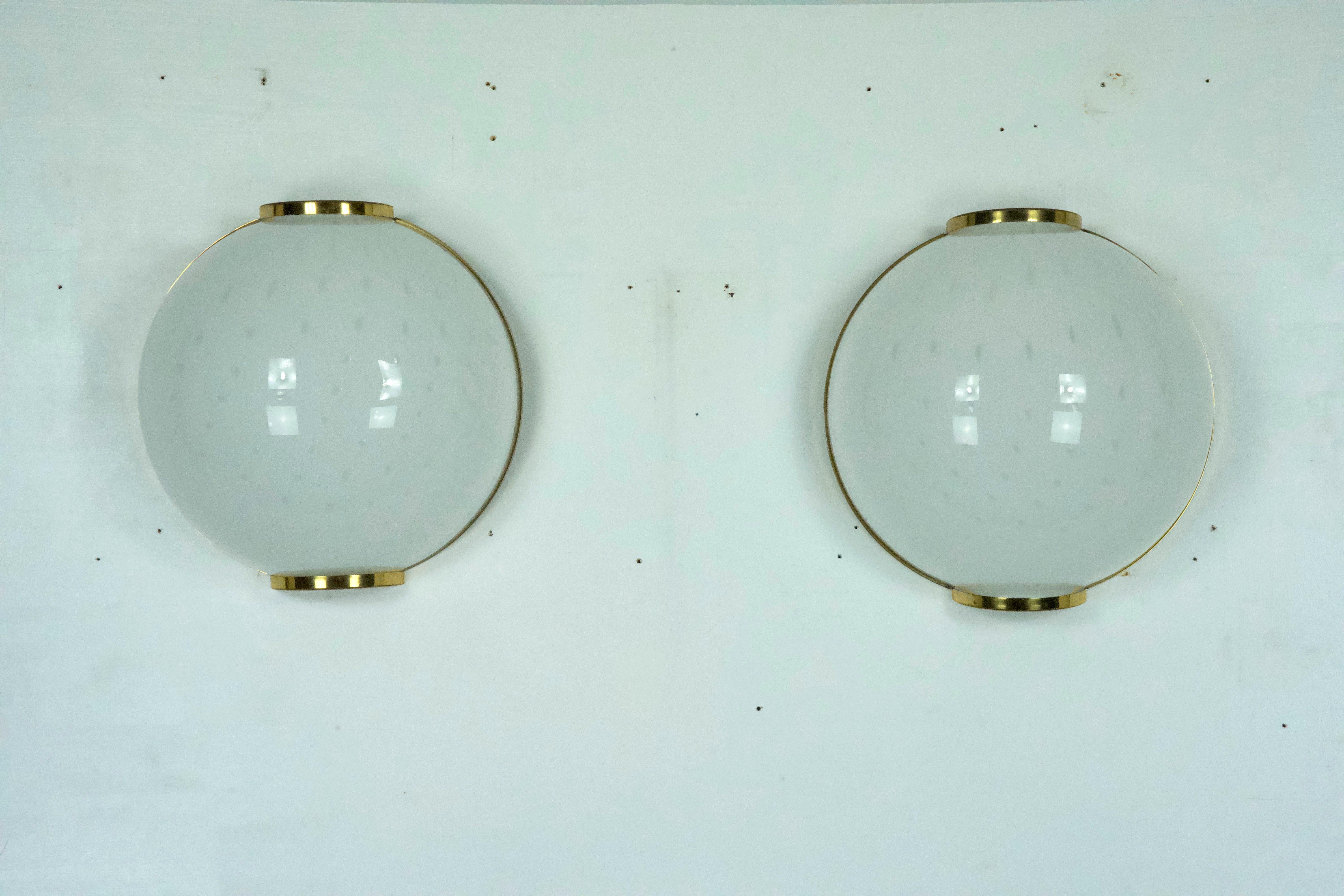 Set of two large round wall lamps in brass and murano bullicante glass. Produced in Italy during the 1970s. Great vintage condition with slight trace of age and use. No chips or cracks. Full working with EU standard, adaptable on demand for USA