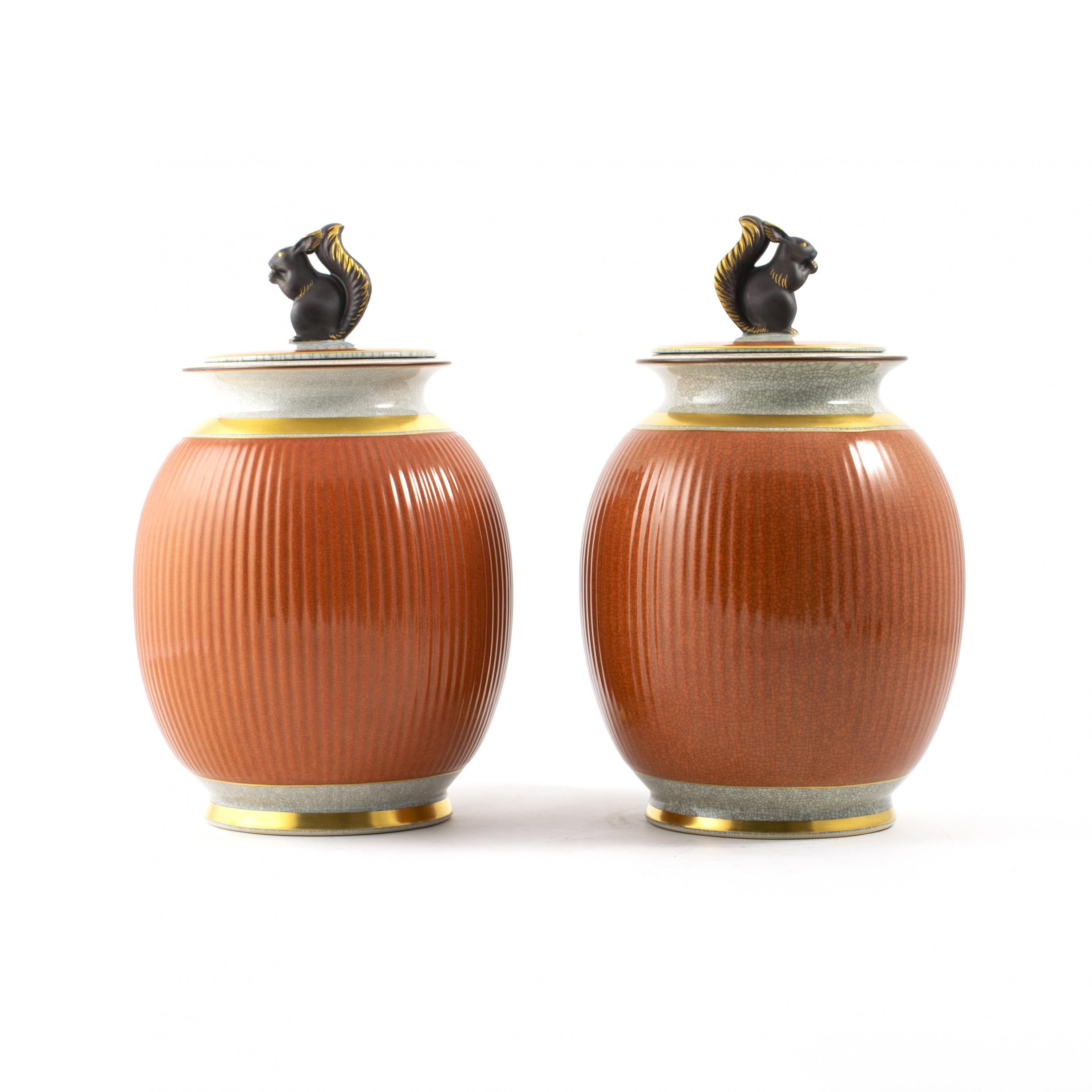 Pair of Royal Copenhagen porcelain vases.
Terra cotta and grey crackle glaze with gold trim and lid decorated with a squirrel.
Very decorative both with and without lid.
Stamped and numbered underneath.
Sold as a pair.

Measurement (cm):