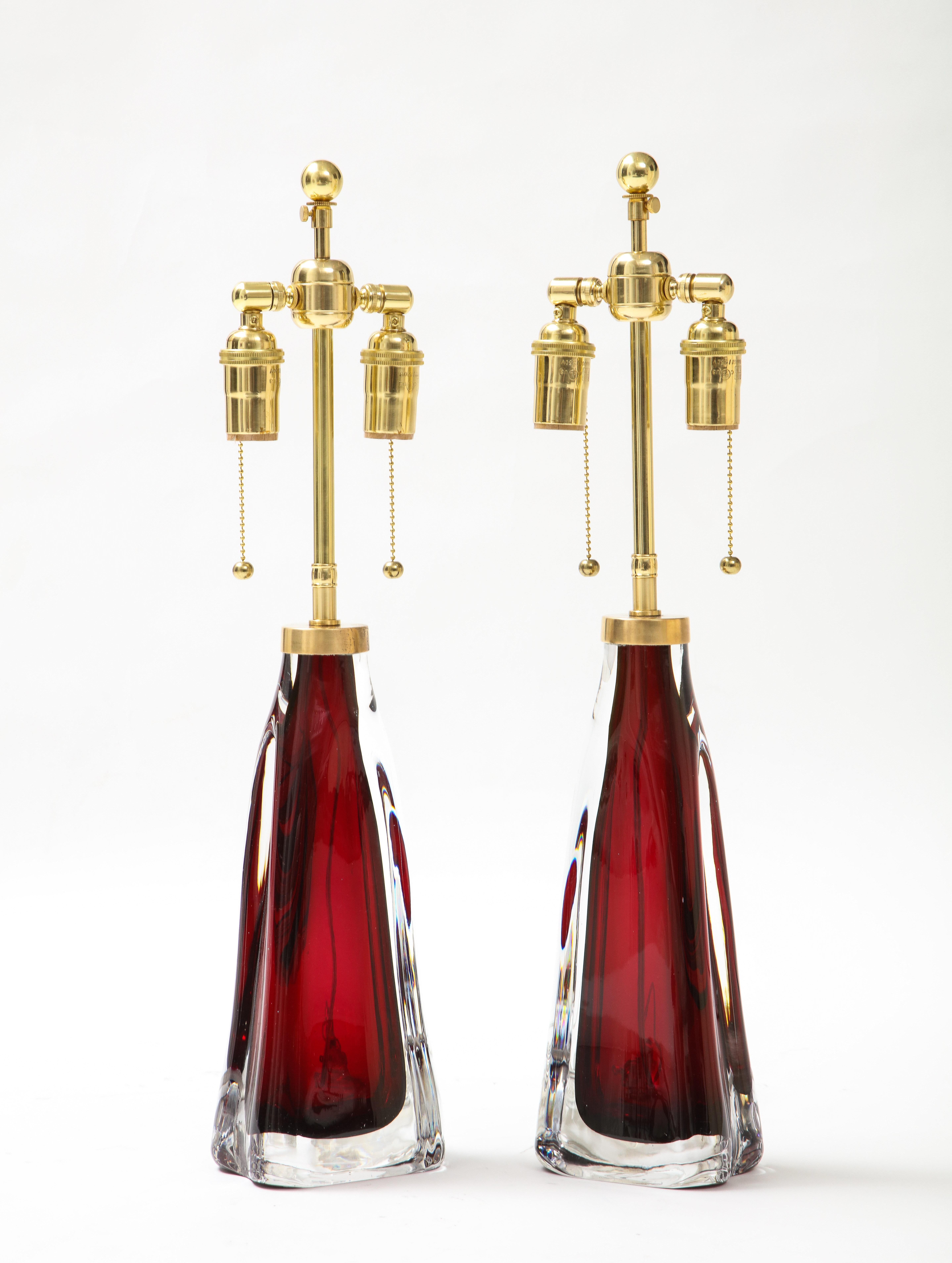 Pair of large crystal lamps lamps in a beautiful ruby red color by Orrefors.
The lamps have been Newly rewired with adjustable brass double clusters that take standard size light bulbs.
The height to the finial is 23.5