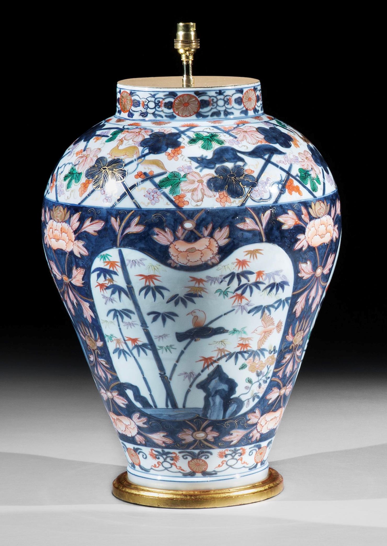 Une superbe paire de grands vases et couvercles en porcelaine continentale du 19ème siècle, probablement Samson. Chaque vase est magnifiquement décoré dans la palette Imari, avec des pavillons sur des rivages rocheux, réservés sur un fond bleu peint