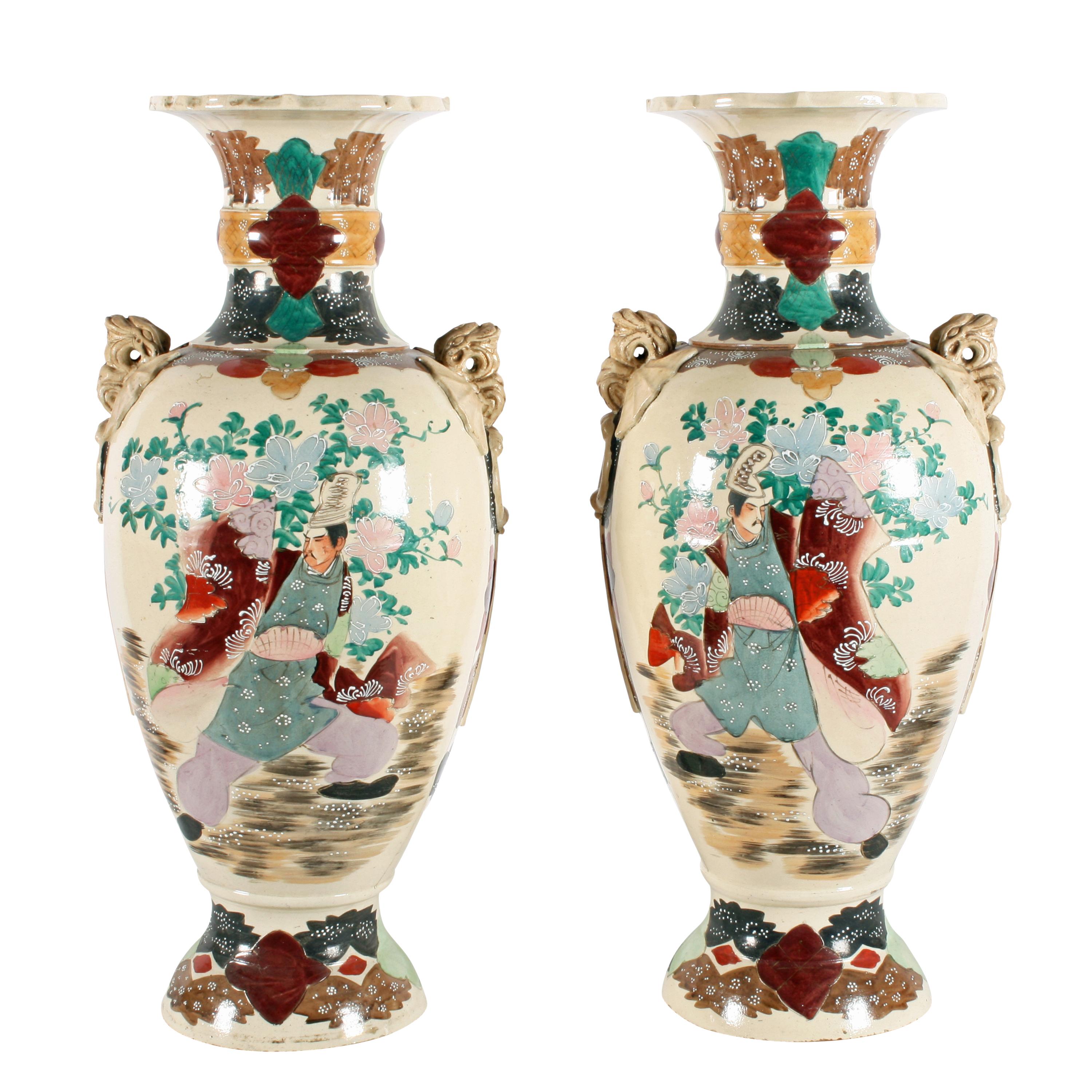 A large pair of early 20th century Japanese Satsuma pottery vases.

The vases are decorated with scenes of Samurai warriors to one side and figures in traditional dress to the other.

The shoulders of the vases have flat ring handles with dragon