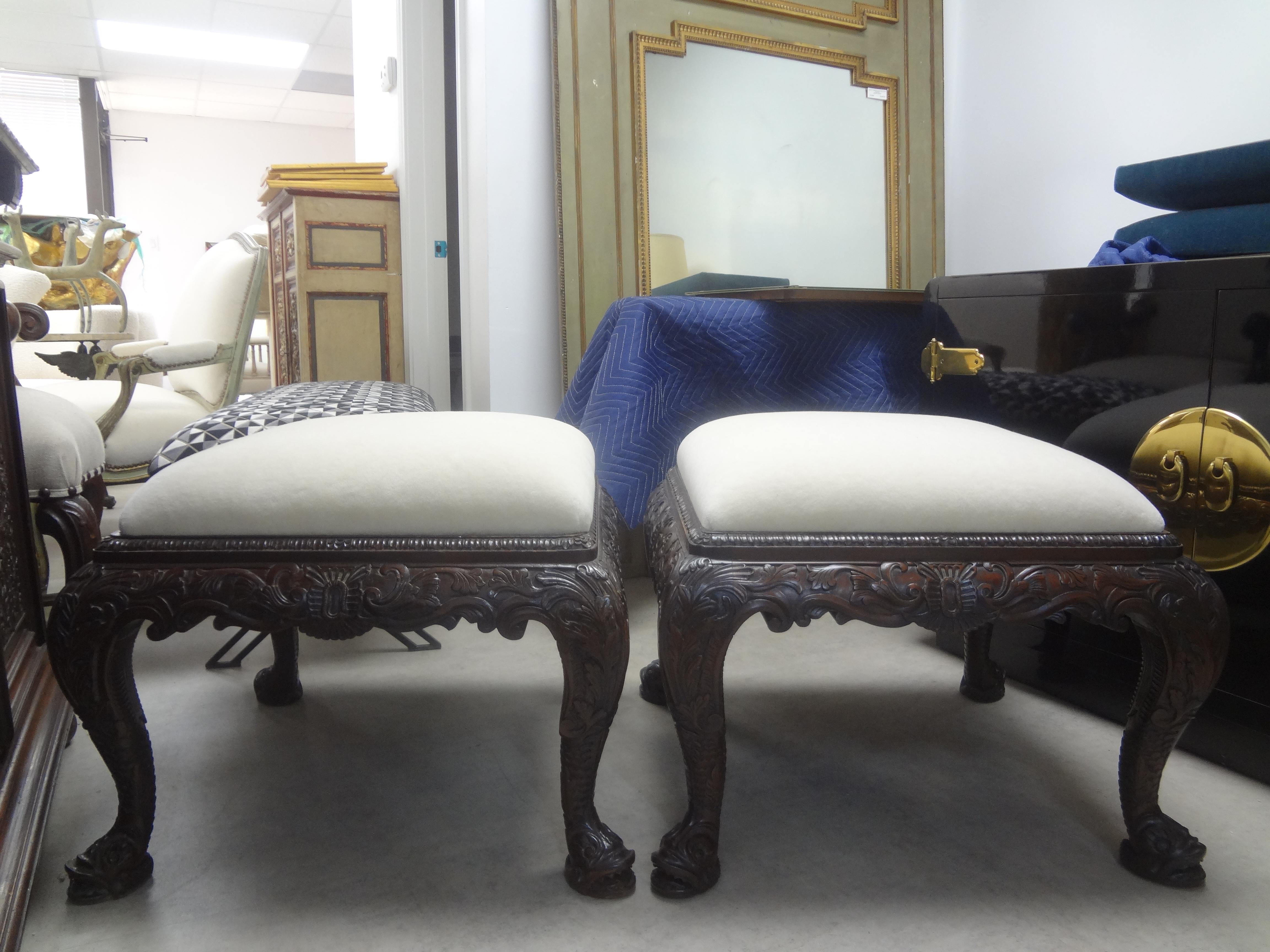 Paire de grands ottomans anciens de style Régence anglaise à grande échelle avec pieds en forme de dauphin. Ces grands bancs ou poufs de style Régence étonnants sont magnifiquement sculptés sur tous les côtés et sont suffisamment grands pour