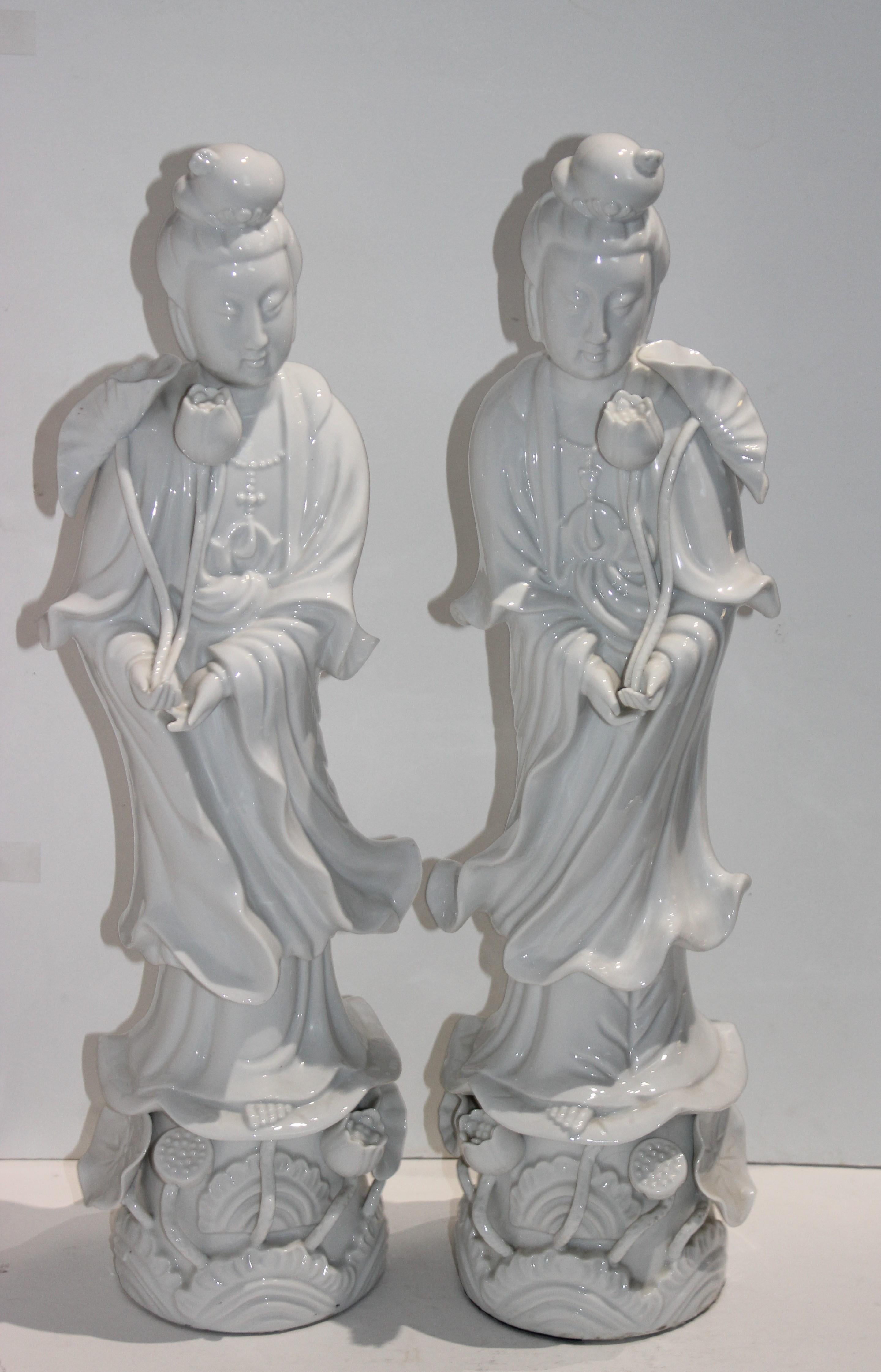 This stylish and chic pair of blanc de chine Quan Yin figures date to the 1960s and were originally purchased in Hong Kong and were recently acquired from a Palm Beach estate. 

There is a small hairline on the base of one of the figures which