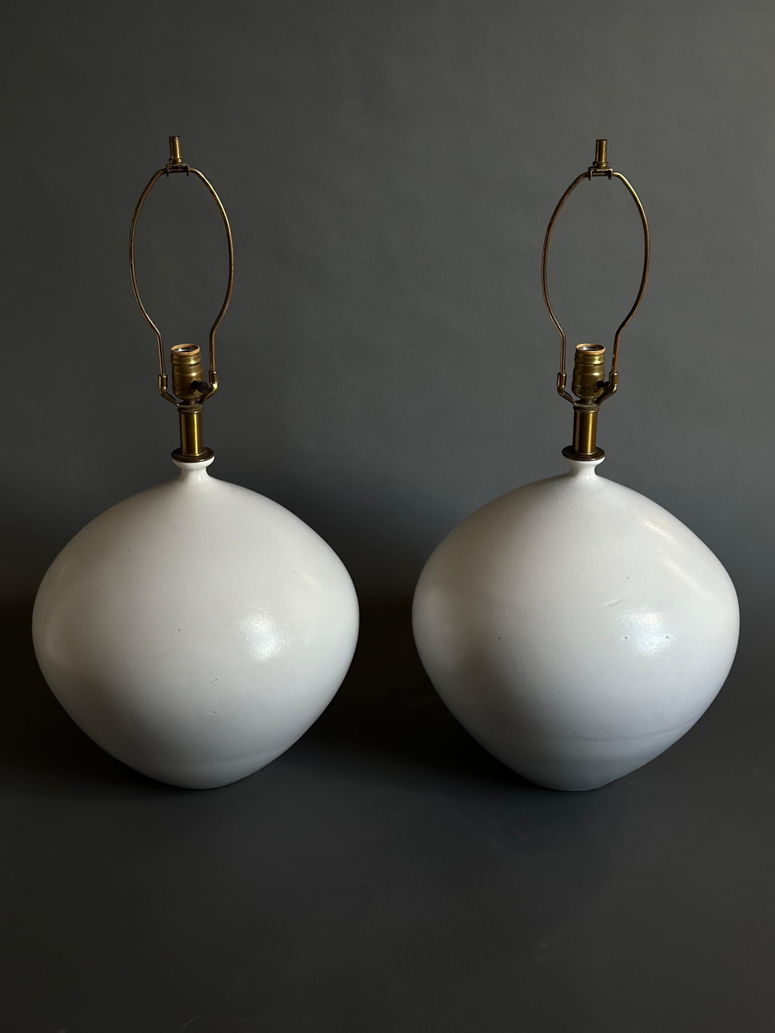 Ein Paar handgedrehte Keramik-Tischlampen in runder Form aus der Serie 3300, Modell 3301, entworfen von Lee Rosen für Design Technics, mit einer matten, milchweißen Glasur. Ein robustes Design mit einem Gewicht von 25 Pfund pro Lampe. Beide sind mit