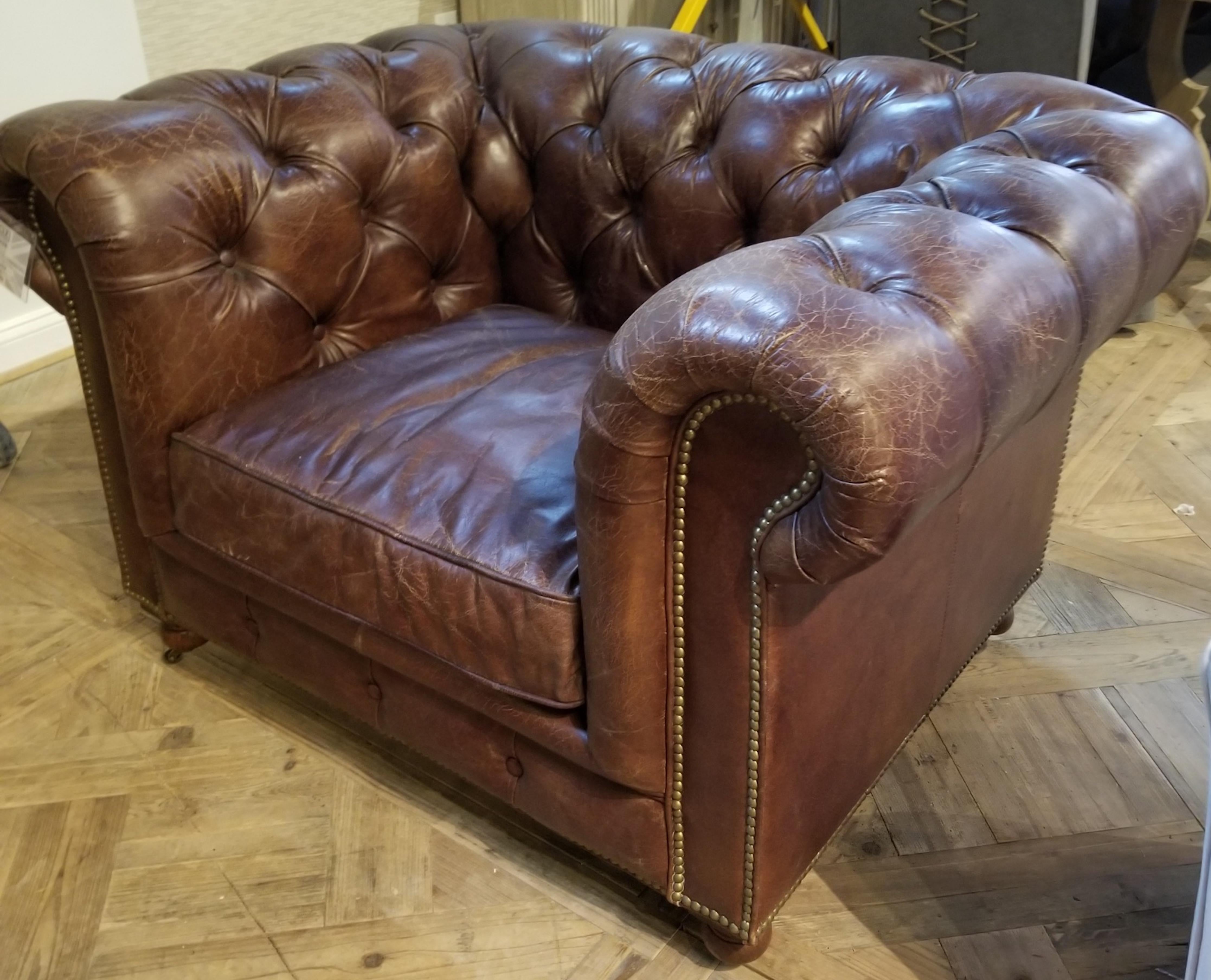 One pair of large-scale Chesterfield club chairs with distressed leather. Leather is in pristine condition with a lovely distressed finish. Crackle effect can be left as is or played down by conditioning them. Priced per chair.  We also have two 96