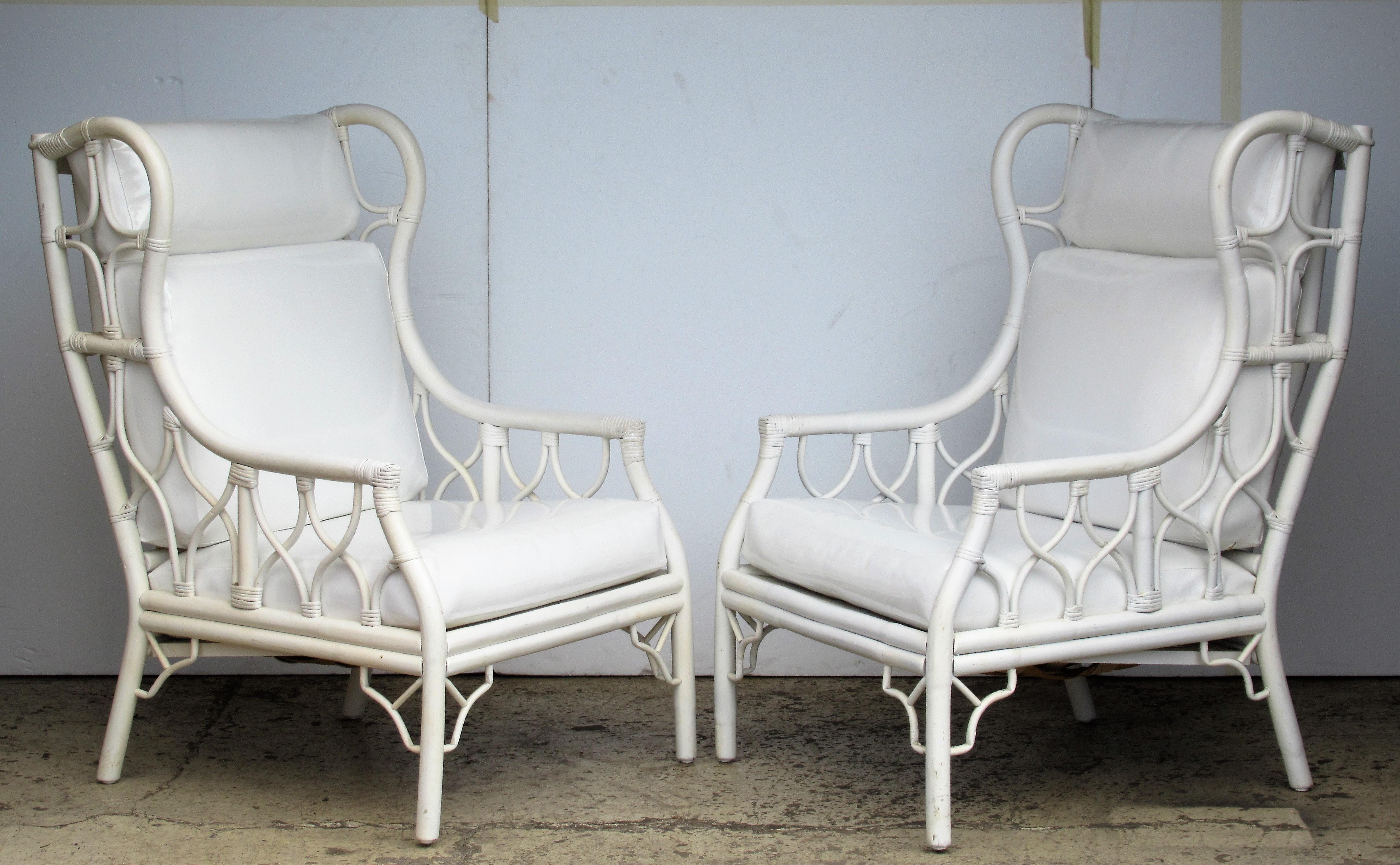 A very glamorous large scale pair of rattan Hollywood Regency / Chinese Chippendale style wing back chairs in white enamel painted finish and beautifully upholstered faux white patent leather seat and back cushions, circa 1960 - 1970. These are