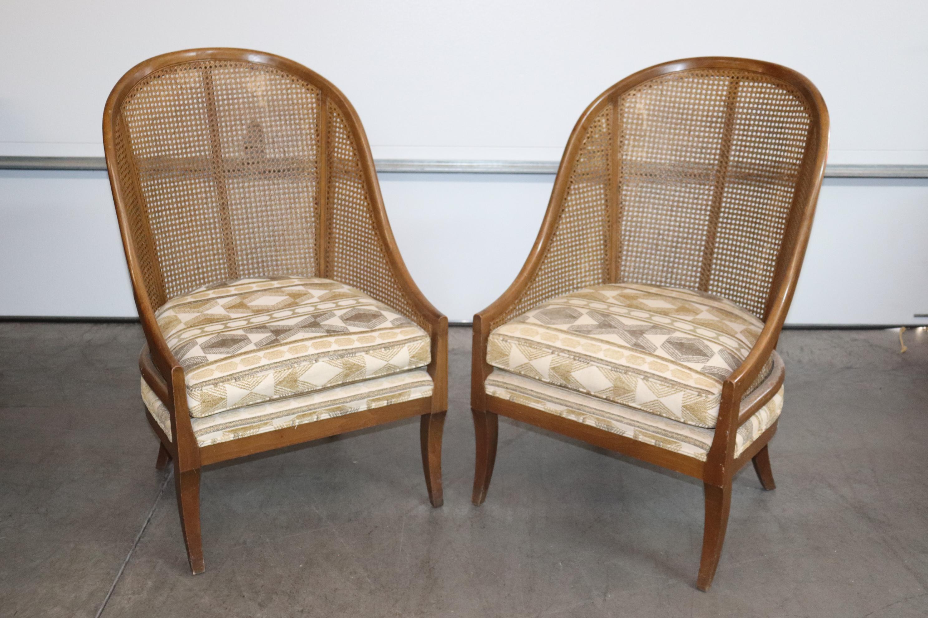 This is a unique pair of English Regency style cane back tub style bergere chairs. The chairs are in their original vintage condition with minor wear to the cane as shown in the photos. The cane is fine but the finish or lacquer has some wear. The