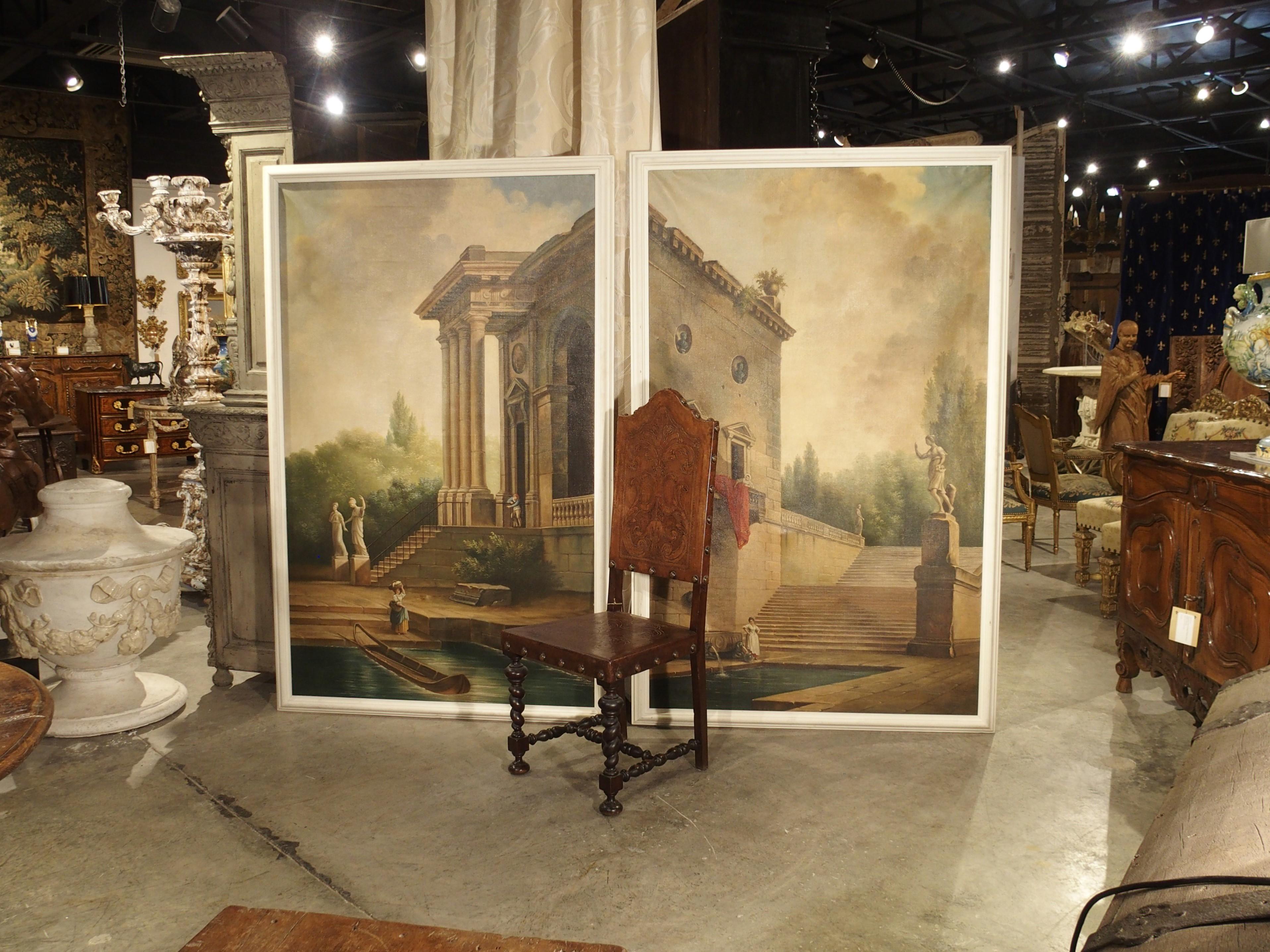 At over six feet tall, this pair of Italian landscape paintings from the early 1900s make quite a statement. The oil on canvas paintings are framed with white painted wood and are considered Capriccio paintings, which essentially means they are