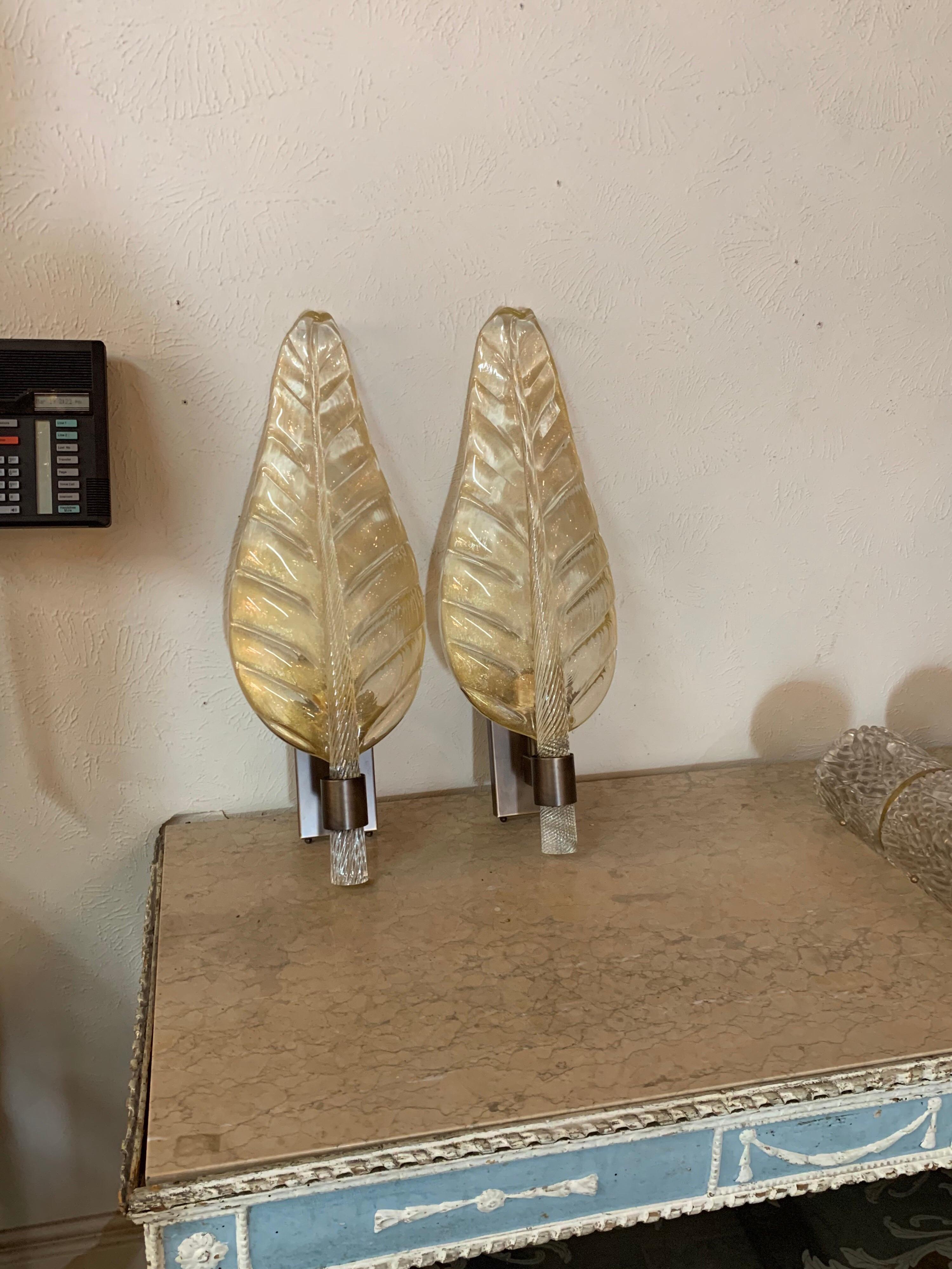 Beautiful pair of large scale Murano glass leaf form sconces by Bavovier and Toso. The clear glass with flecks of gold. A very special designer element! Better hurry, these won't last long!