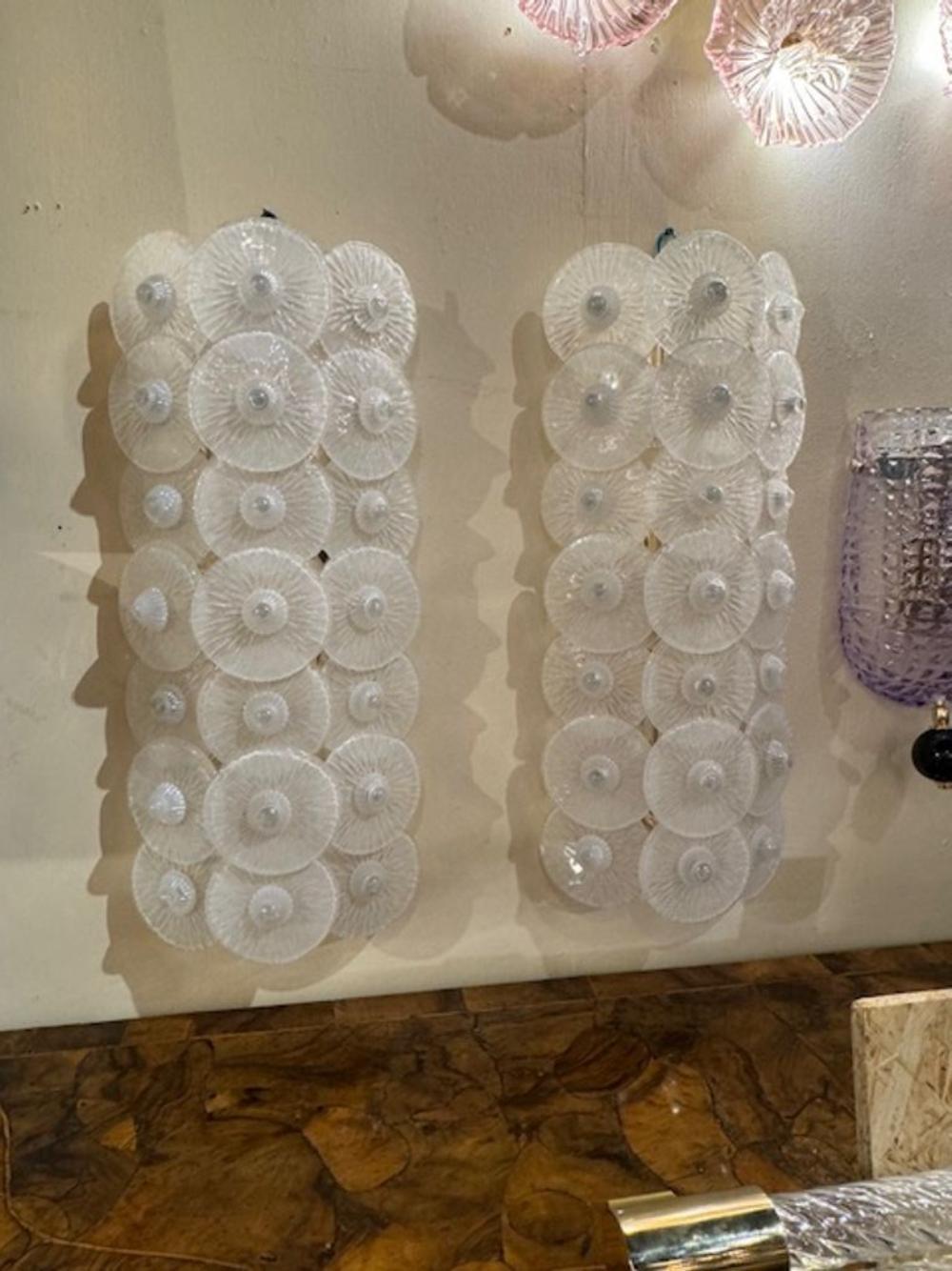 Hübsches, großformatiges Paar Murano-Glas-Leuchter mit mehreren weißen Scheiben. Erzeugt ein sehr strukturiertes Aussehen. So schön!!! Zwei Sets verfügbar.
26h x 11w x 5d