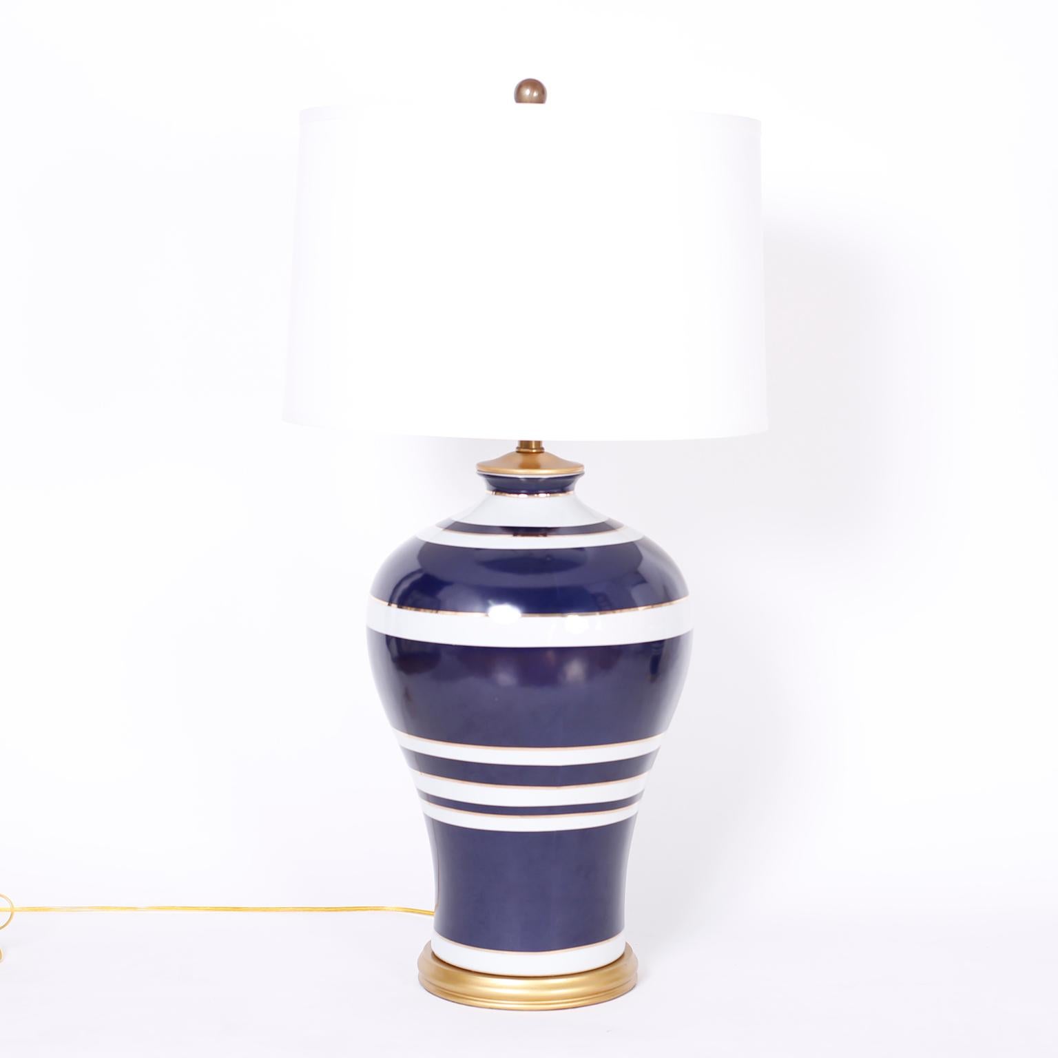 Chic pair of large scale table lamps crafted in porcelain with a Classic form and decorated with blue and white stripes. Signed Ralph Lauren on brass plaque.