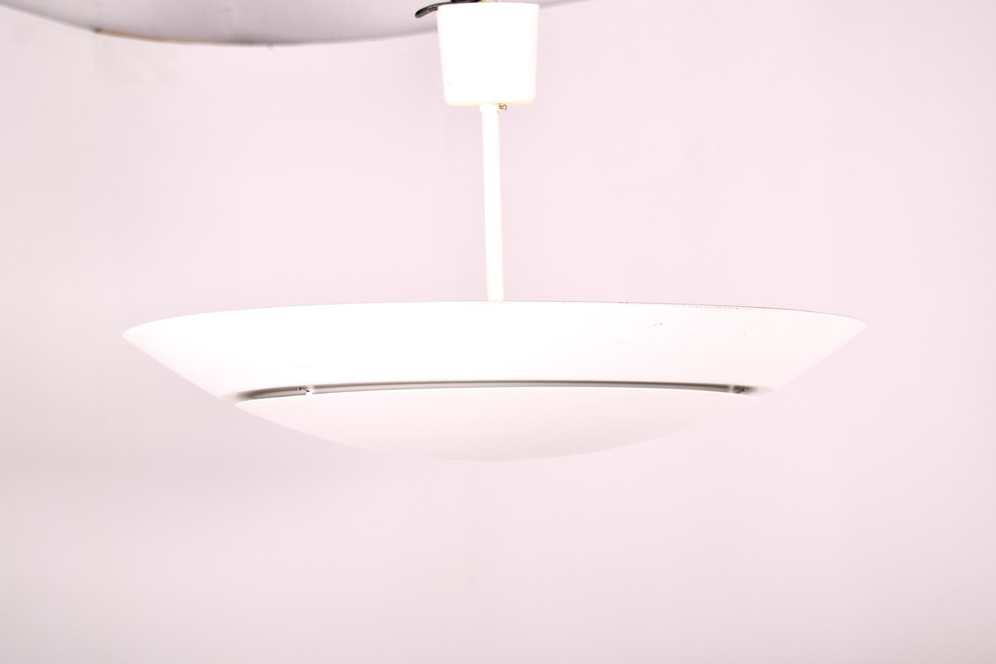 Questa coppia di grandi lampade da soffitto scandinave della metà del secolo scorso emana l'etica del design elegante e funzionale che contraddistingue il design europeo del XX secolo. Realizzate in alluminio laccato bianco, queste lampade incarnano