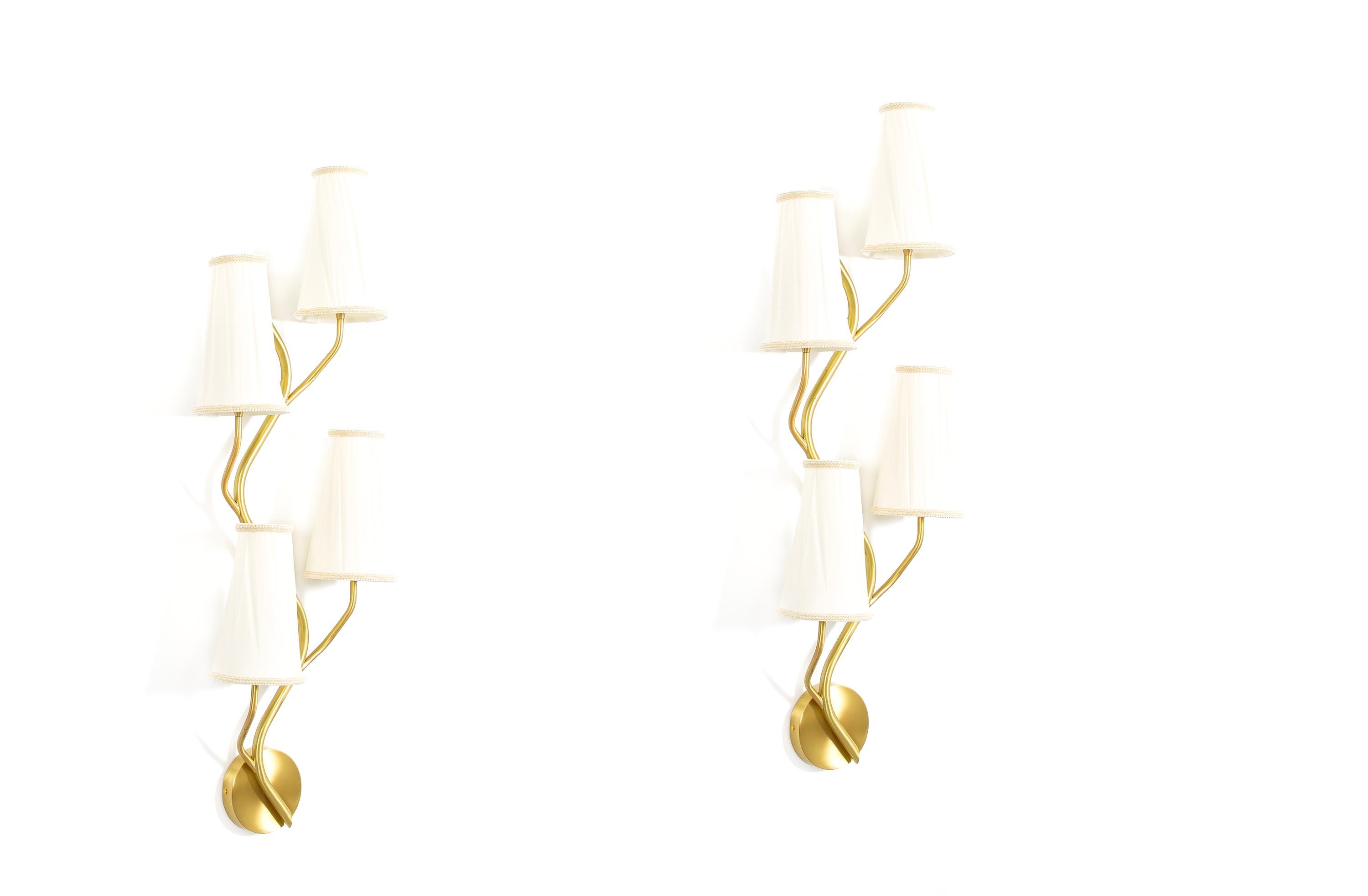 Wonderful pair of sculptural, organic, and highly decorative wall lights in brass with four arms and soft nylon shades. Designed in Norway by Astra and crafted by skilled artisans, these refined fixtures take inspiration from the rich legacy of