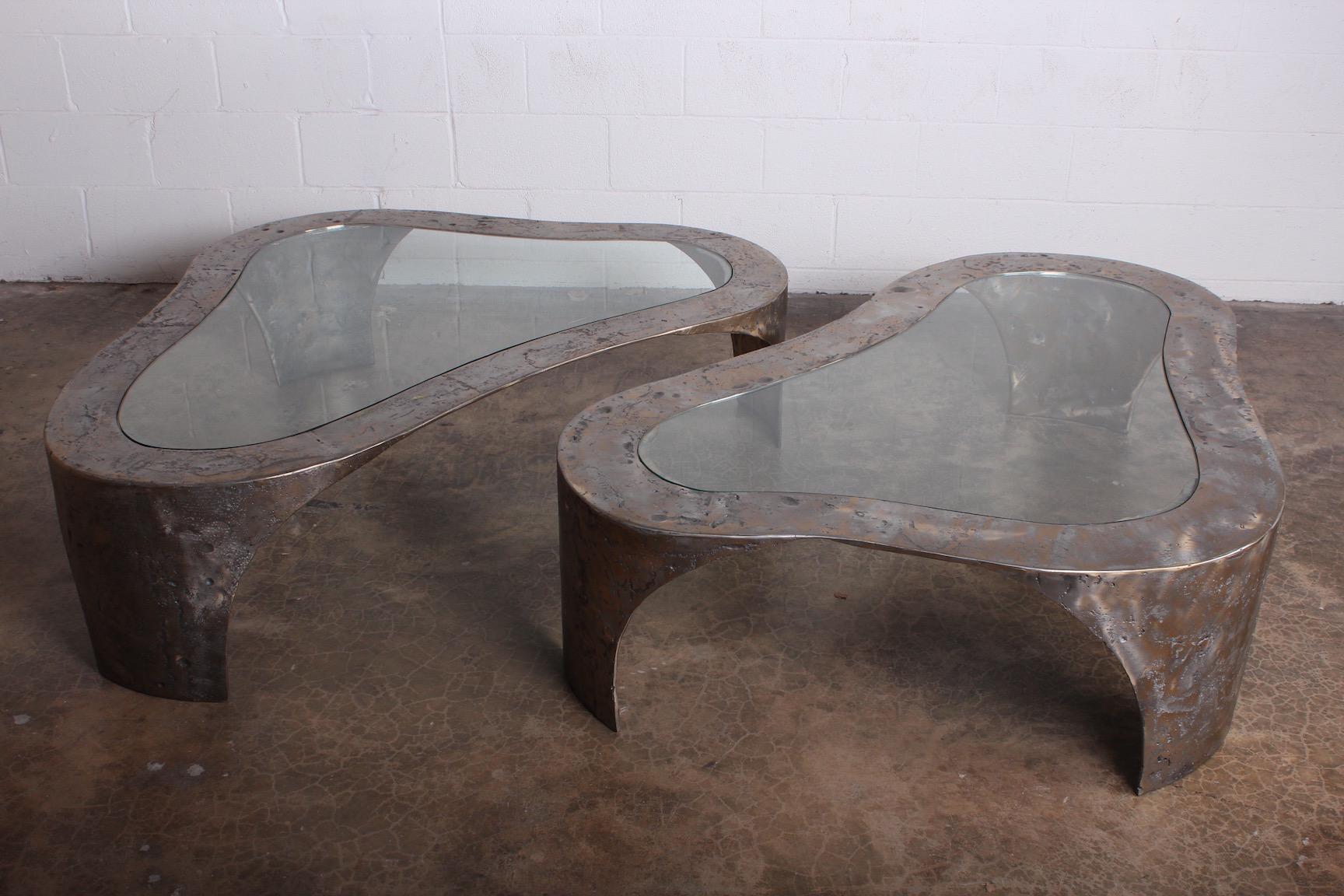 A matching pair of large scale pewter finished bronze tables with inset glass tops. Both signed by Silas Seandel.

Measures: Table one 60 x 44 x 16
Table two 59 x 40 x 16.
