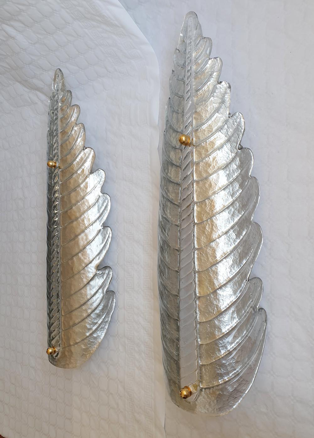Very large pair of Mid-Century Modern Murano glass wall sconces, attributed to Barovier & Toso, Italy 1970s.
The vintage leaf shaped sconces are made of a single handmade Murano glass, in a silver color, with a transparent glass center rod and brass