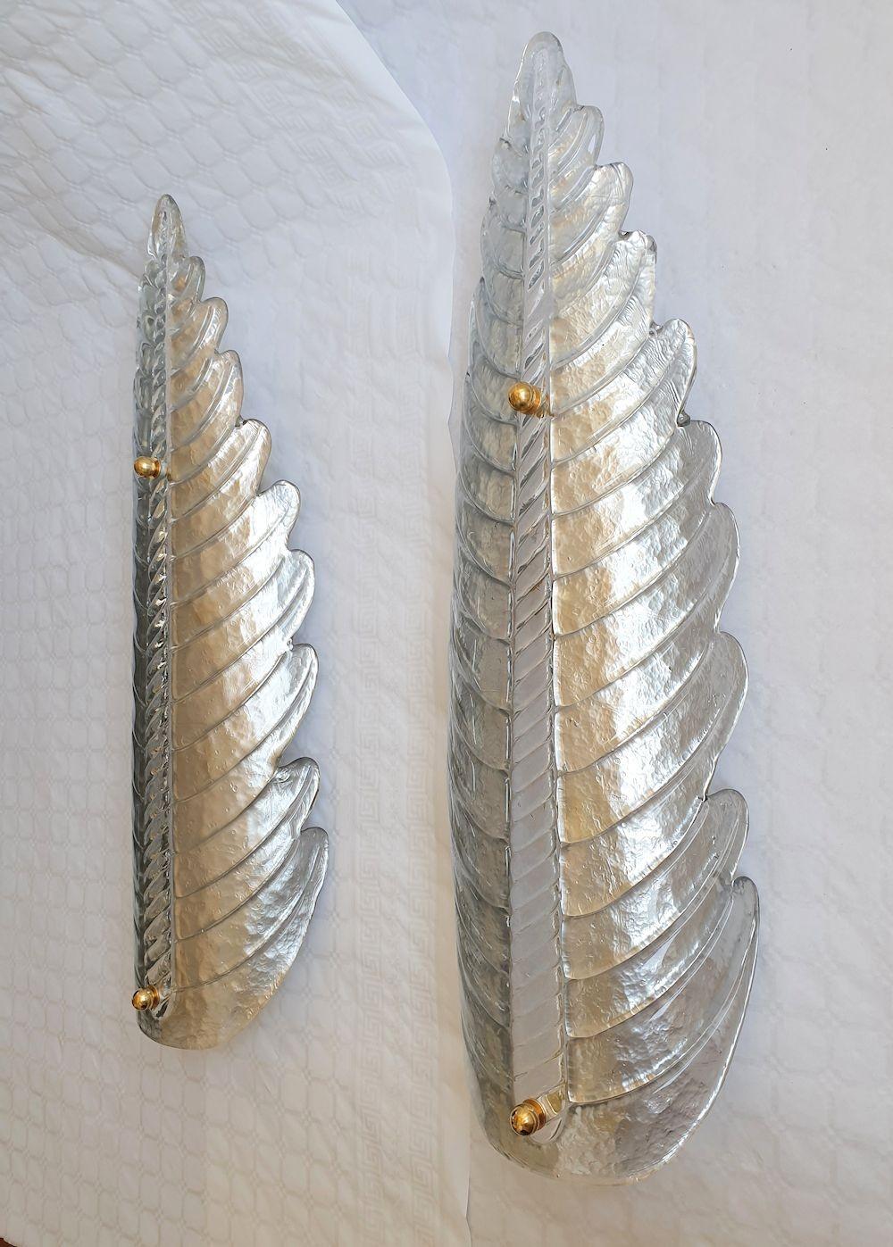 Very large pair of vintage silver Murano glass wall sconces, attributed to Barovier & Toso, Italy 1970s.
The Mid Century Modern leaf shaped sconces are made of a single handmade Murano glass, in a silver color, with a transparent center rod and