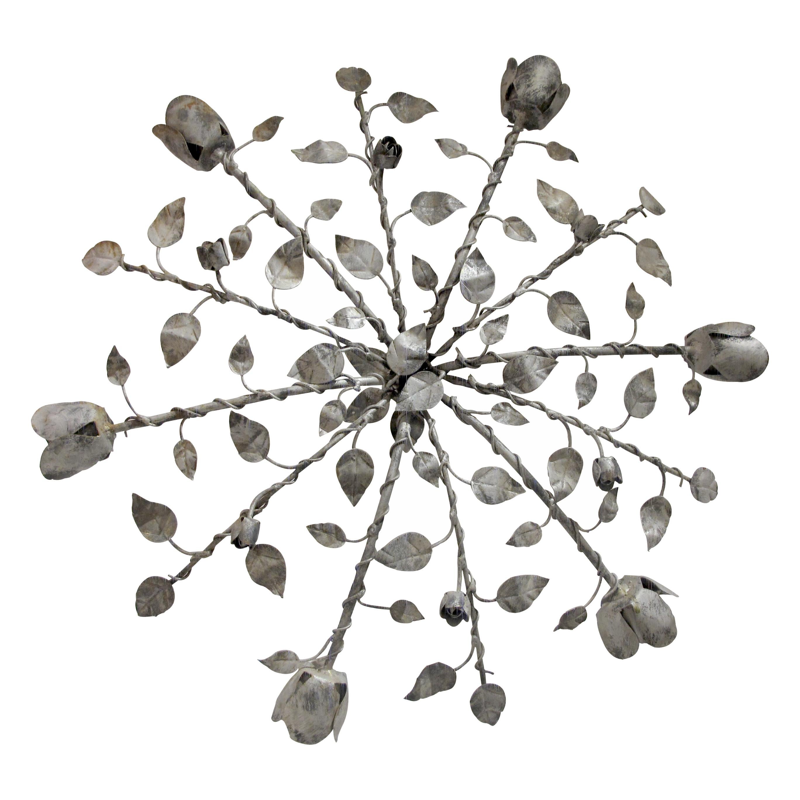 Questa elegante coppia di grandi plafoniere da parete, realizzate a mano, proviene dalla Spagna e risale agli anni Cinquanta. Realizzata in ferro robusto e verniciata in argento, ogni lampada presenta motivi floreali e steli di ferro attorcigliati,