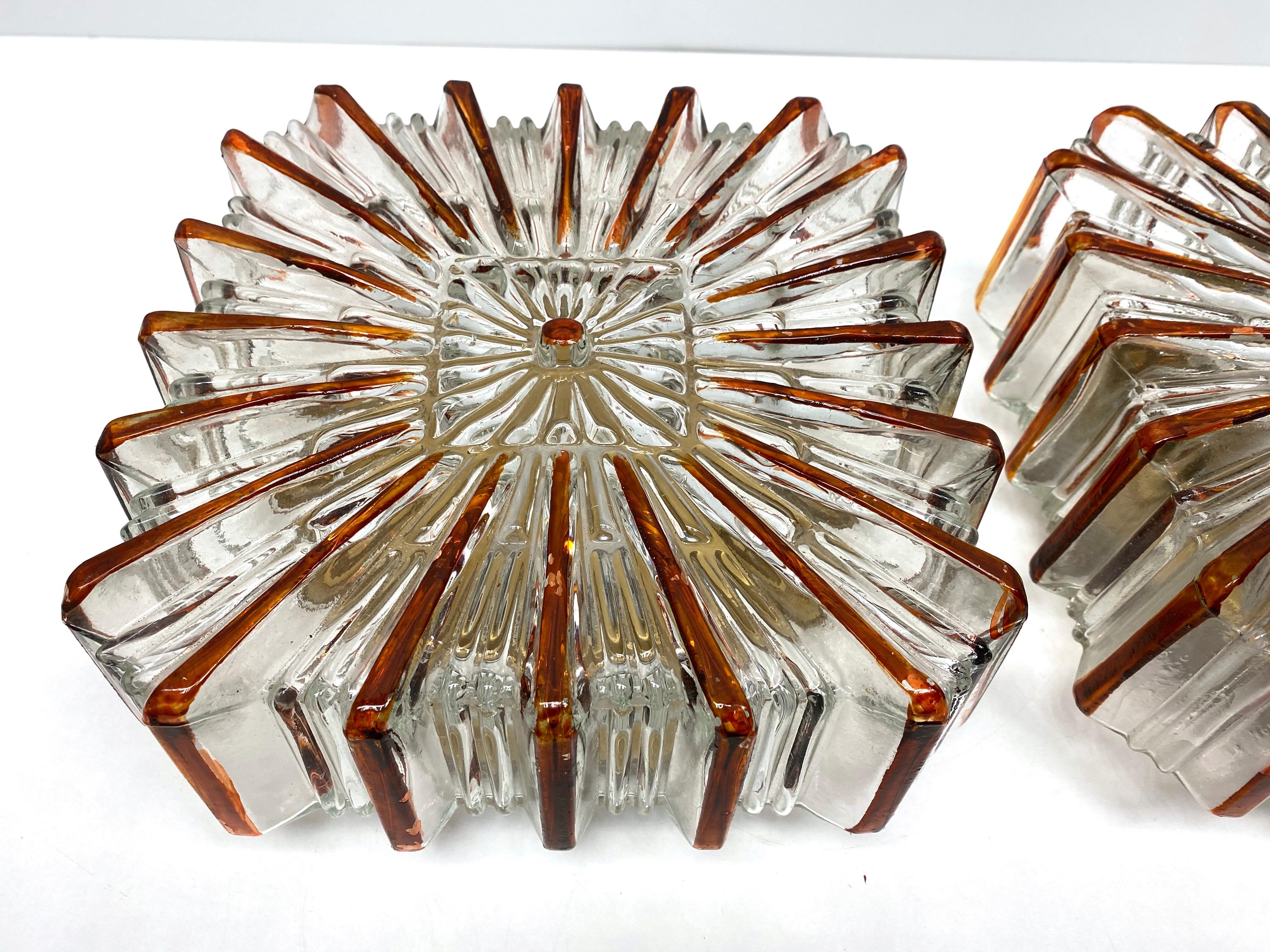 Beautiful pair of starburst pattern flush mounts. Made in Germany by Glashuette Limburg. Gorgeous textured glass flush mount with metal fixture. Each Fixture requires one European E27 / 110 Volt Edison bulb, up to 75 watts. These Lights are about 50