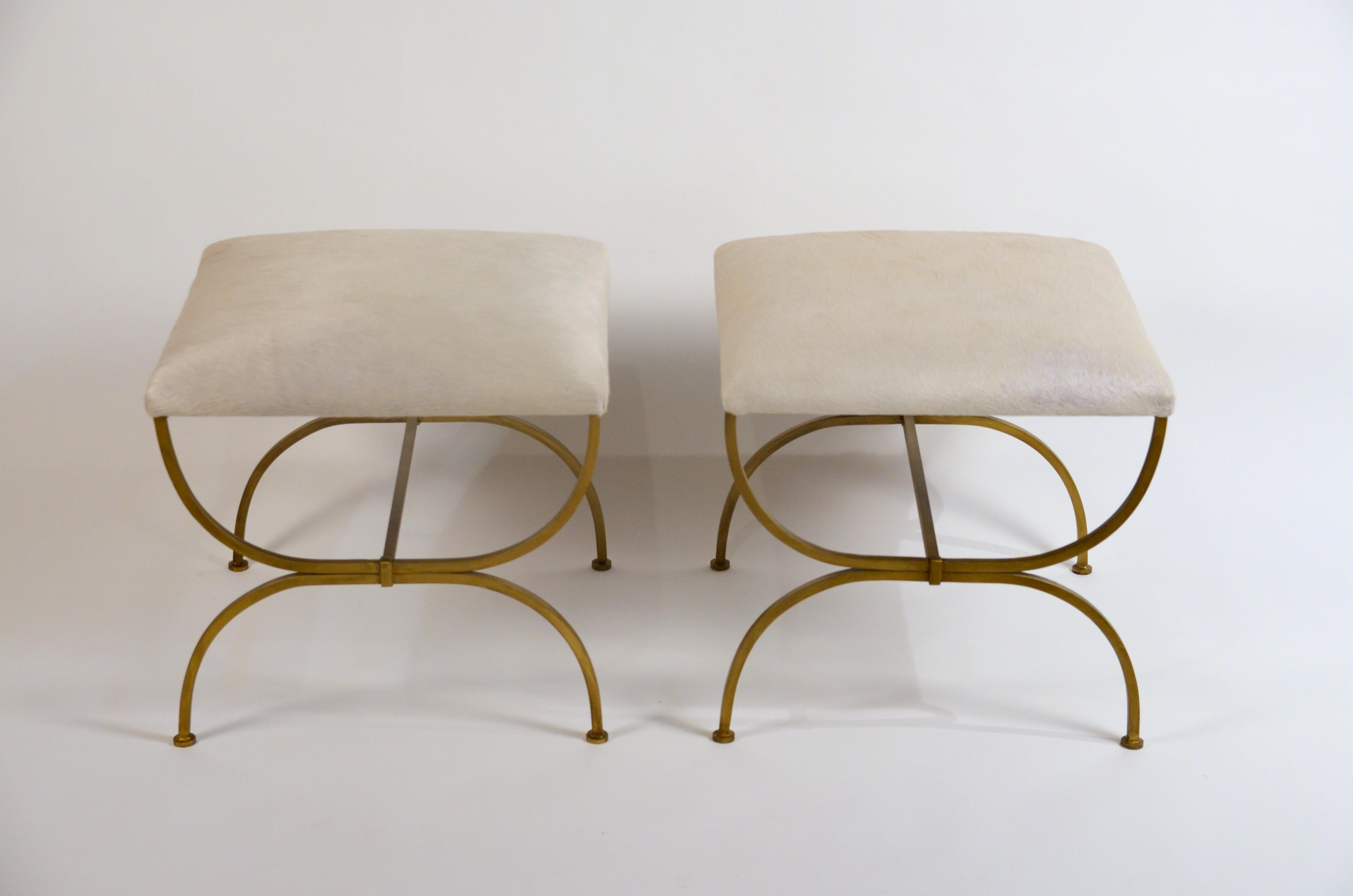 Pair of large 'Strapontin' white hides stools by design Frères. Gilt wrought iron bases and white or cream hide seats. Upholstered firm for durability.