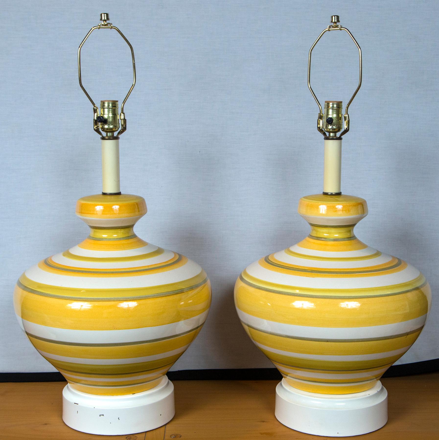 Groovy pair of oversized 1960s yellow with a little avocado green striped lamps. Tall original lamps shades with color coordinated ribbon trim are available, if desired.