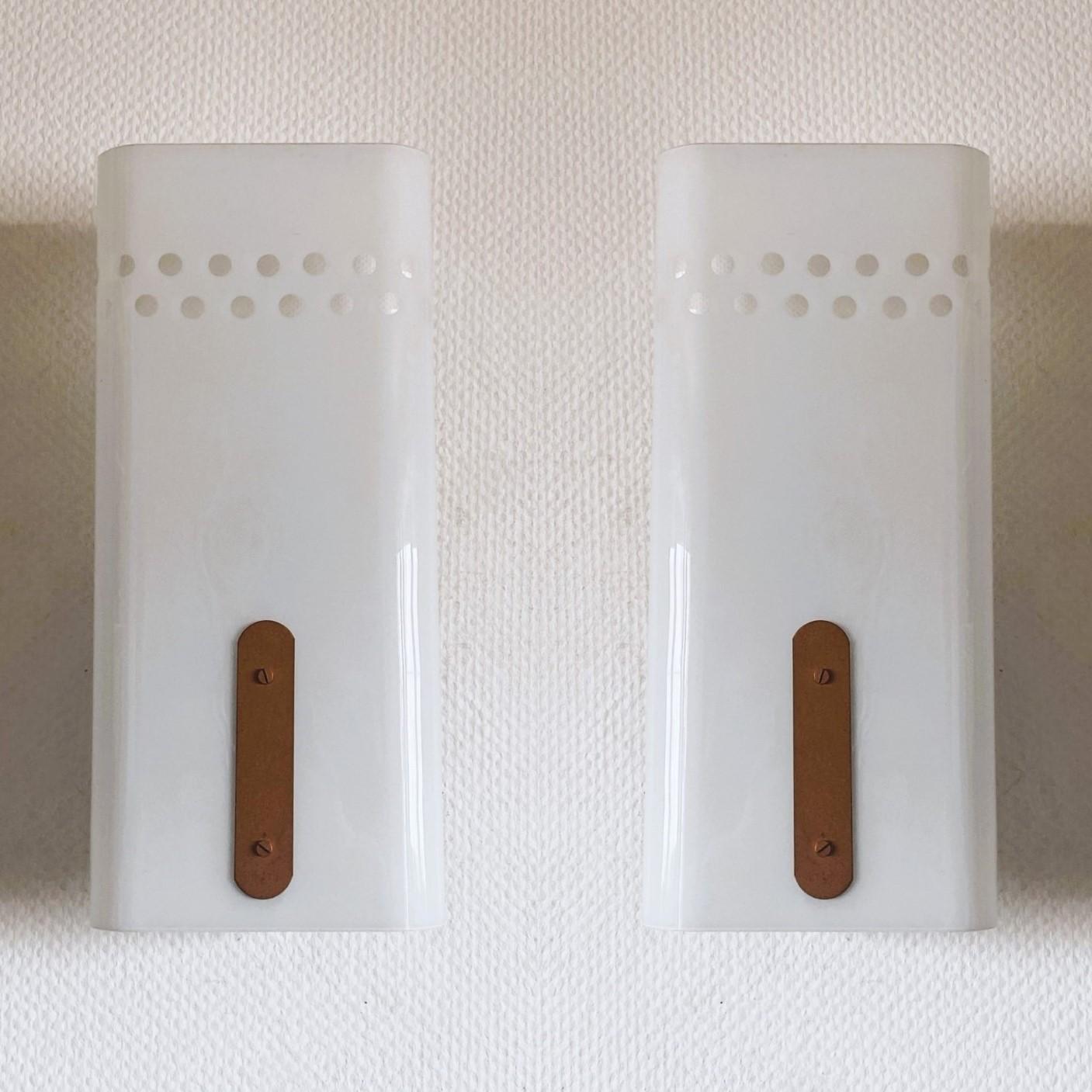A rare pair of large opaline galss and metal three-light cinema wall lamps from Swedish cinema house, 1960s. Clean lines design from the Scandinavian Modern period, with large curved opaline glass with pierced details for better  light projection.