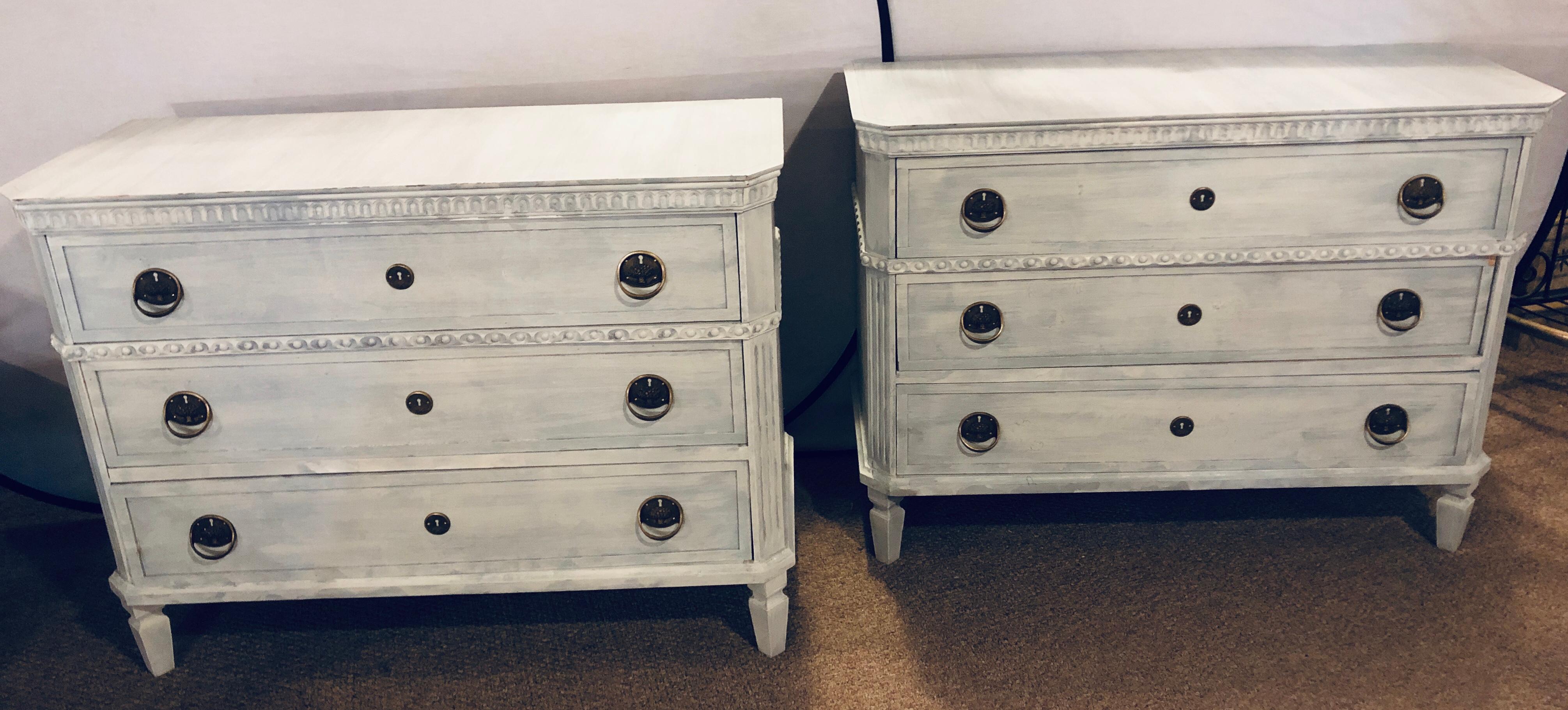 Pair of Swedish paint decorated 3-drawer commodes or nightstands. Each having wood casings with dental mounding and reeded corners leading to rectangular feet.