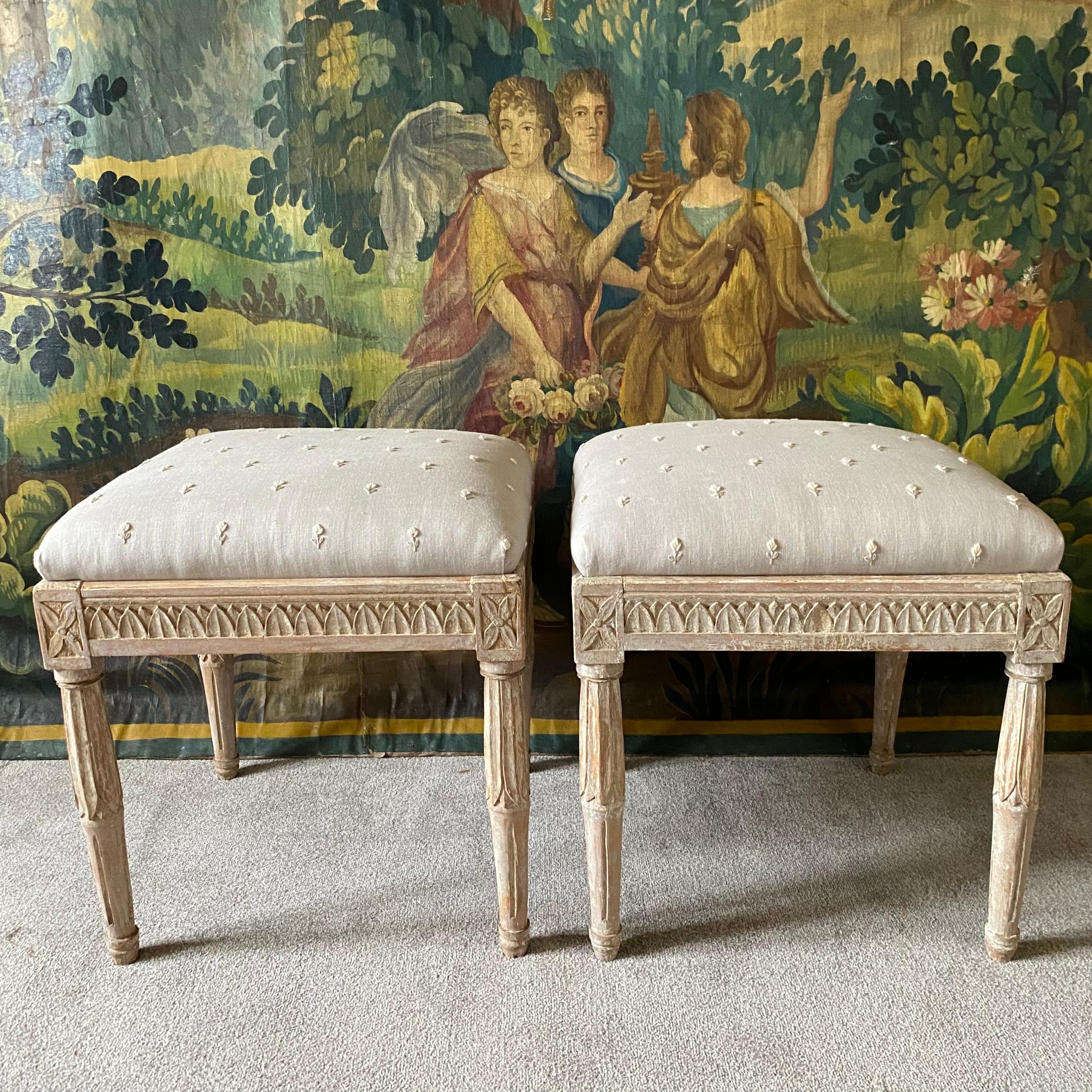 A pair of large Swedish late gustavian stools in original pale paint finely carved to all four sides - drop in seats have been recovered in a hand embroidered flower sprigged pure linen ( little white flowers on a soft blue grey background) easily