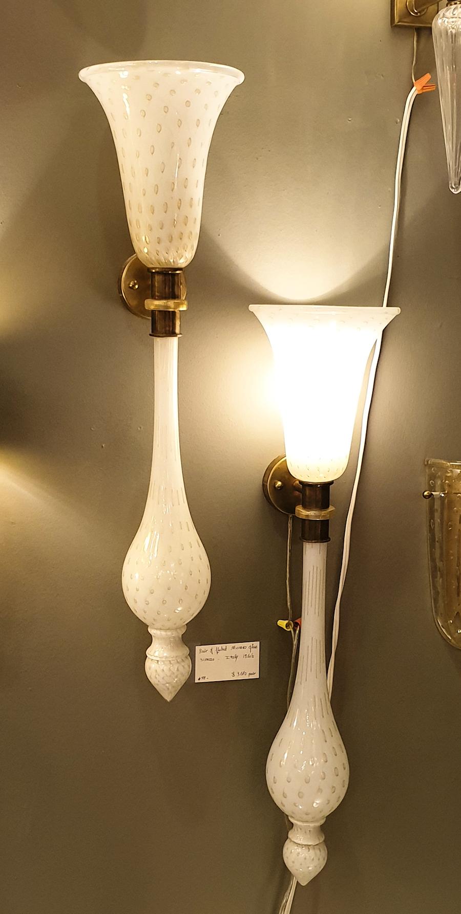 Pair of large Torchiere Murano glass wall sconces, attributed to Venini, Murano, Italy, 1960s.
The vintage pair of sconces is made of hand blown white and gold Bullicante Murano glass, with brass fittings.
Bullicante decor means: regular large air