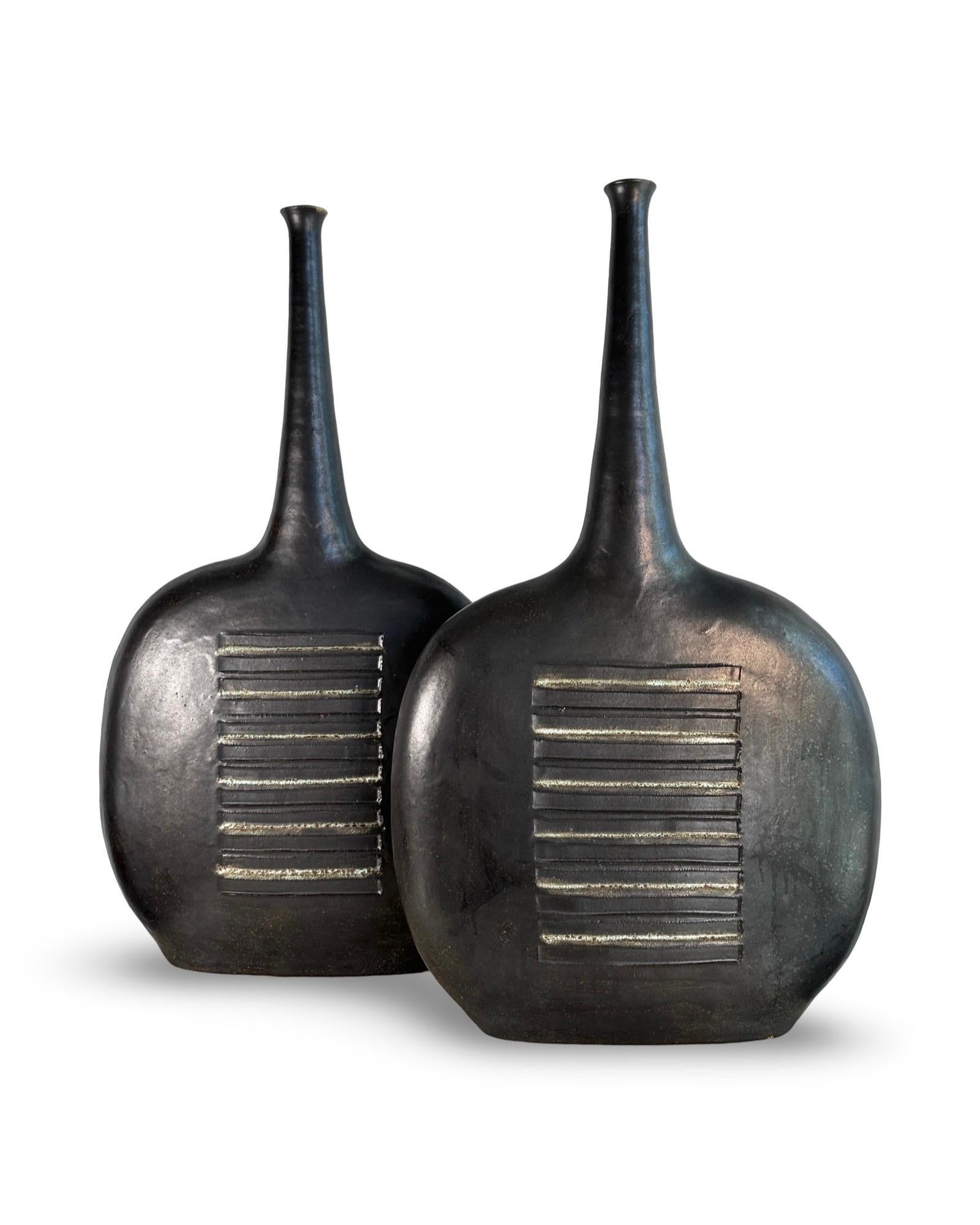 Coppia di vasi di grandi dimensioni di Bruno Gambone, smalto grigio canna di fucile con accenti verdognoli.

Alta 27 pollici, questa coppia di vasi firmati Gambone si presenta bene con un'usura minima.

Il vaso 1 misura 27 x 15,5 x 4
Il vaso 2