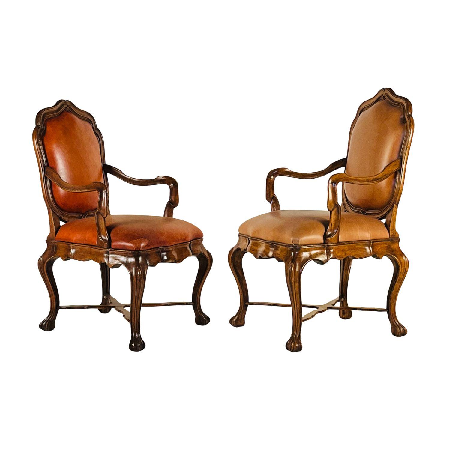 Cette paire d'élégants fauteuils en noyer des ateliers Eleg Studio se distingue par ses proportions impressionnantes et sa finesse d'exécution. Les sculptures sur les boiseries et la sellerie en cuir fin ajoutent une touche de luxe. Ces chaises