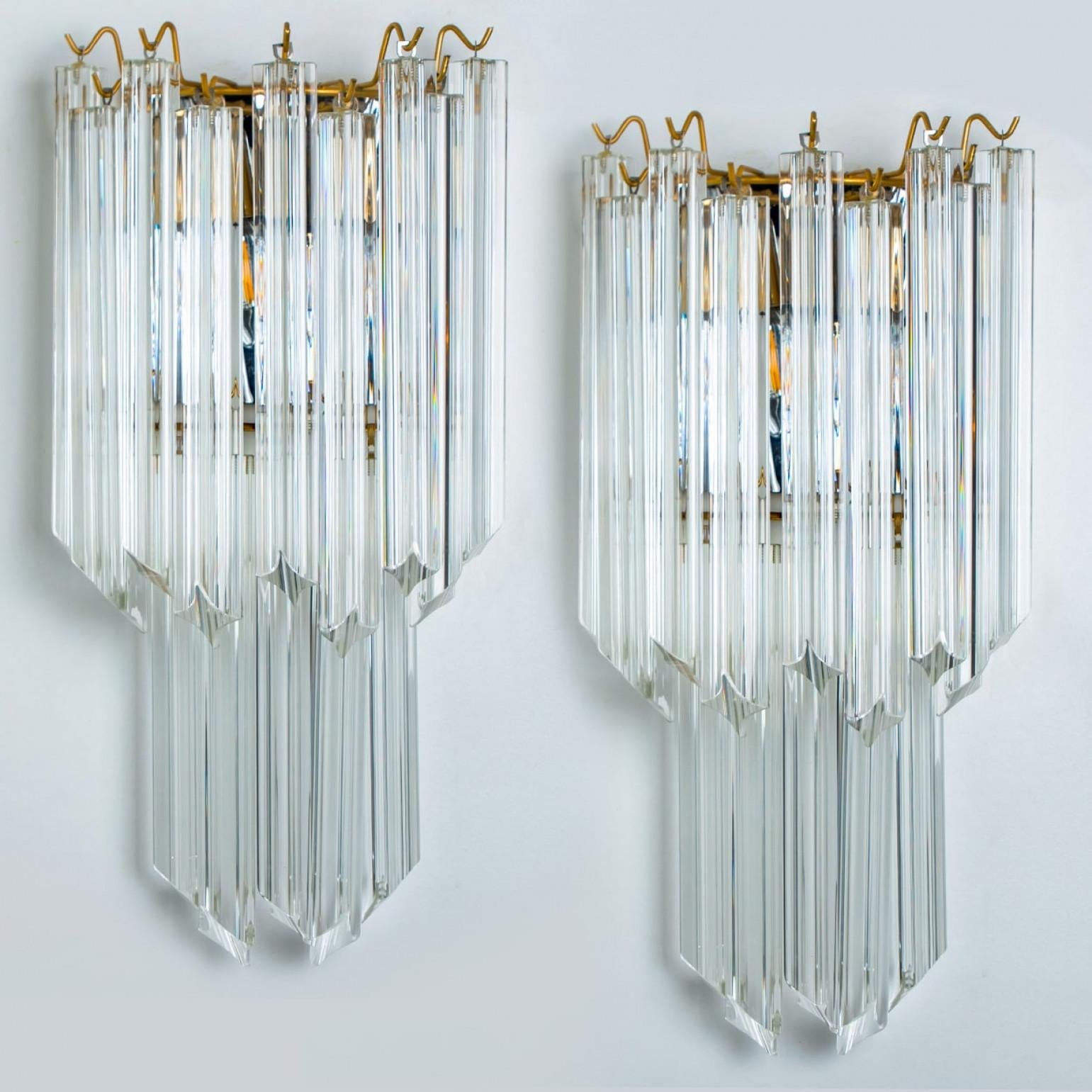 Pair of eautiful triangle shaped glass wall sconces featuring multiple long crystal clear glass tube-like rods, with brass details and back plate. Illuminates beautifully. High-end pieces.

Cleaned and well-wired, in full working order and ready to