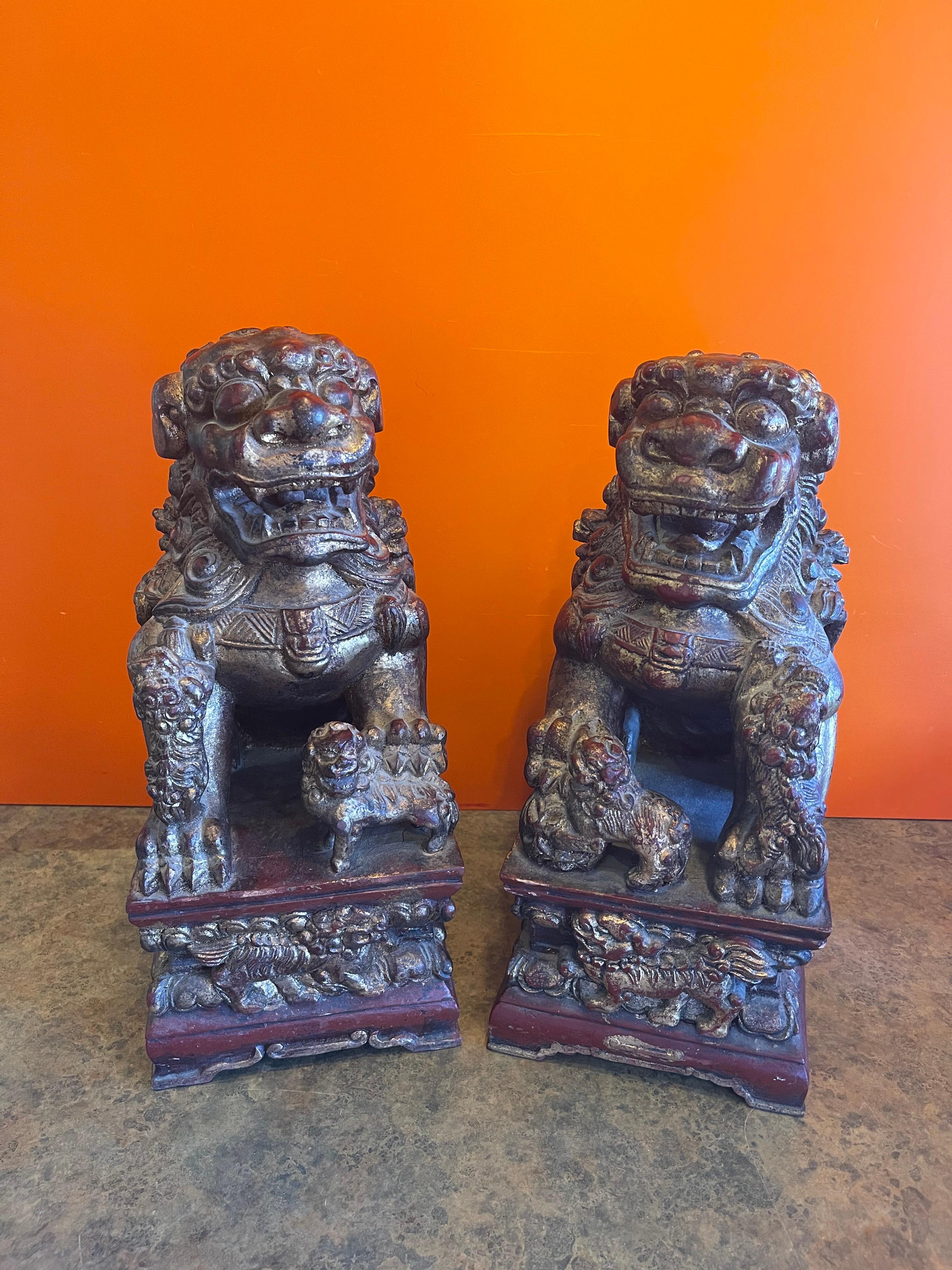 Ein wunderschönes Paar großer, handgeschnitzter chinesischer Hunde aus Holz in tiefem Rot mit schwerer Goldvergoldung, ca. 1960er Jahre. Die Hunde (oder Löwen) sind in sehr gutem Zustand und messen 14