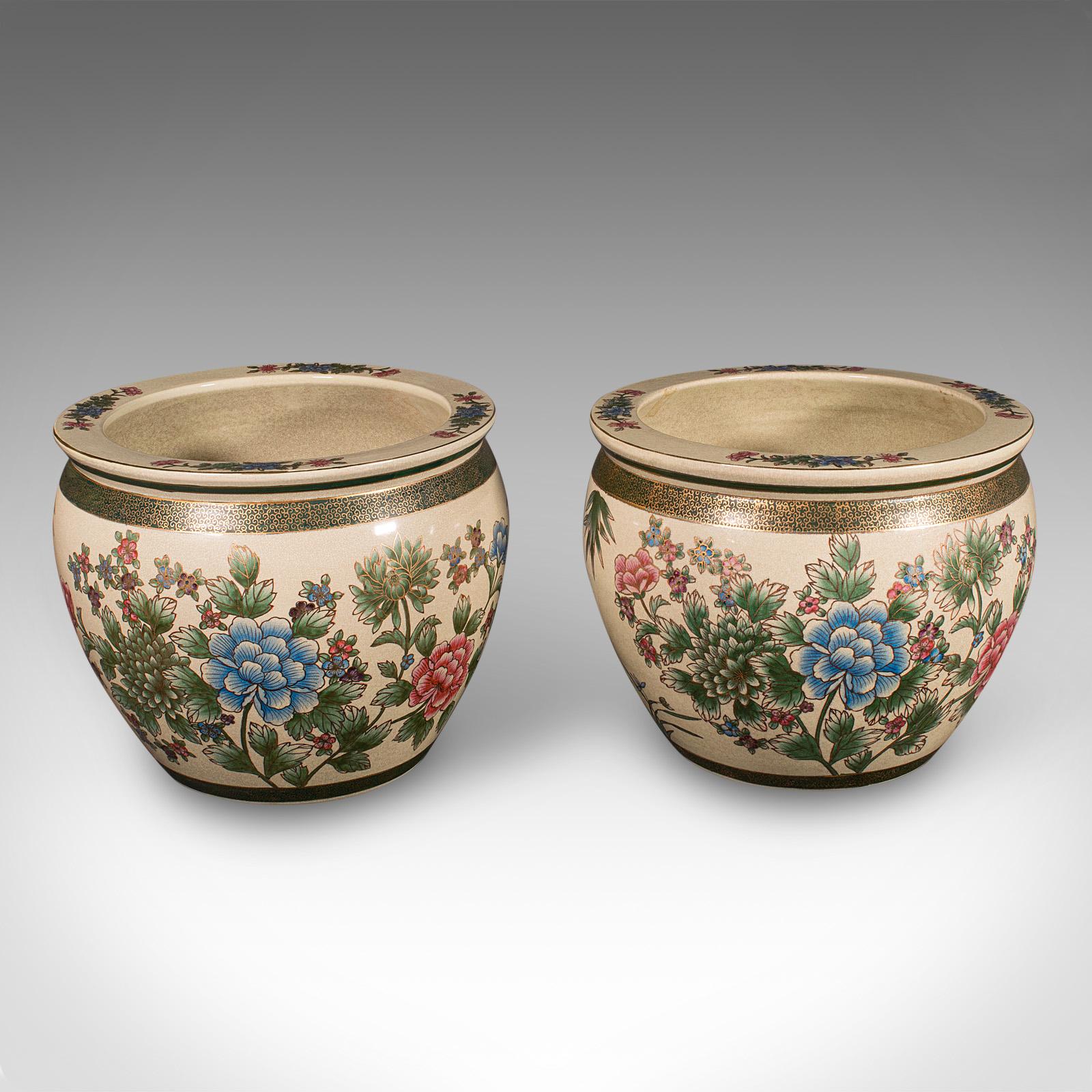 This is a delightful vintage pair of Art Deco period jardiniere pots, showcasing classic Chinese craftsmanship, circa 1930. These large ceramic fishbowl planters offer striking decorative appeal with charming handpainted details.

Elegant vintage
