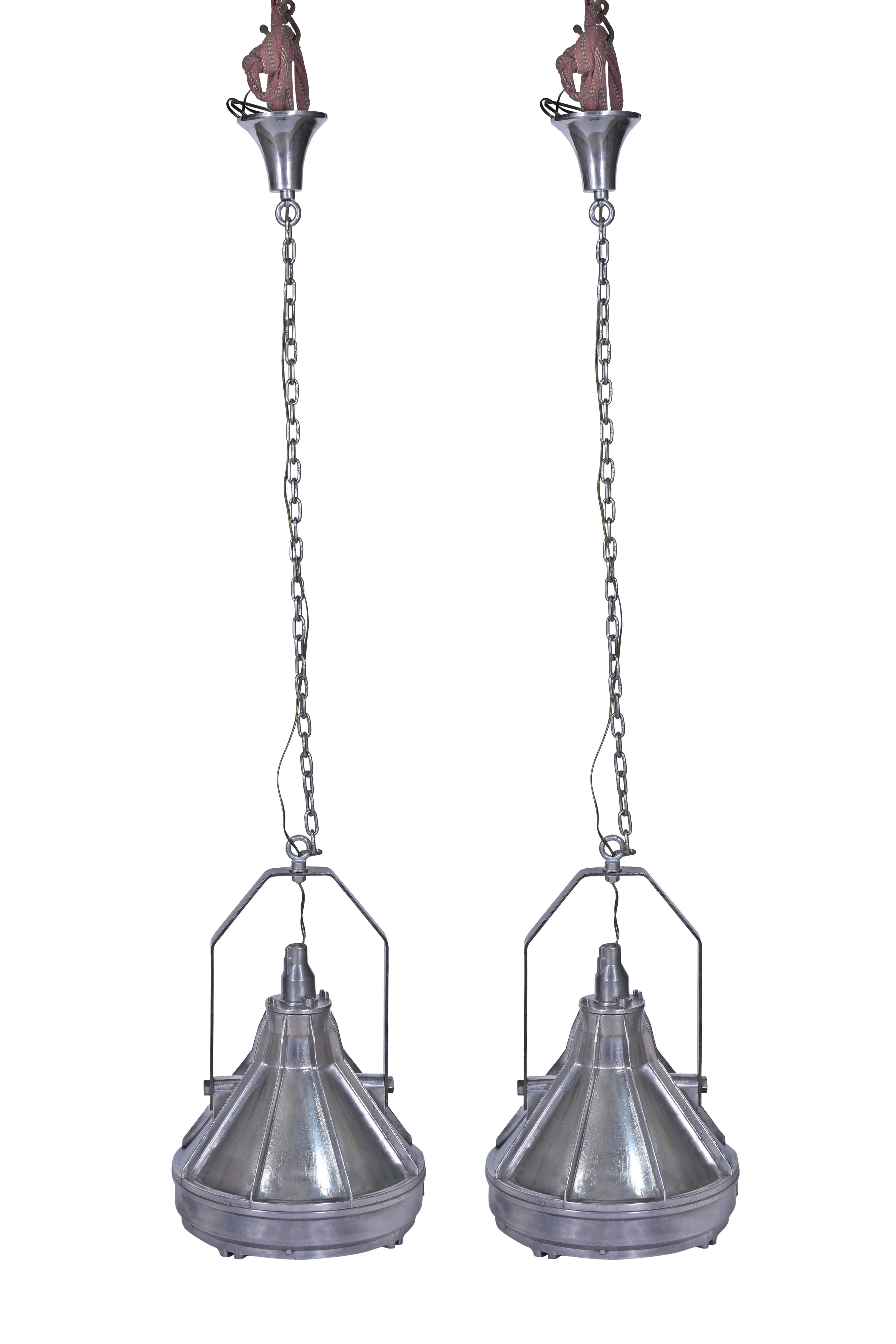 A large and stunning pair of pendant lights which were originally deck lights on a ship.  These have a great chrome patina and have a nice tapered shape with a fin-line texture down the sides.  These have been rewired for American use and takes a