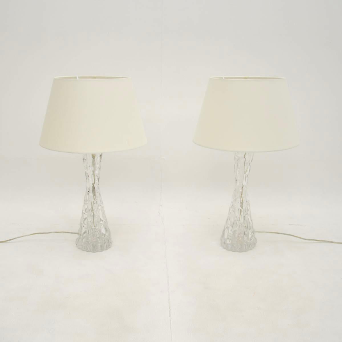 A stunning pair of large vintage Swedish table lamps by Carl Fagerlund for Orrefors, dating from around the 1960’s.

The quality is superb, they are made from chunky, textured clear glass and have a wonderful tapered design. One lamp has the