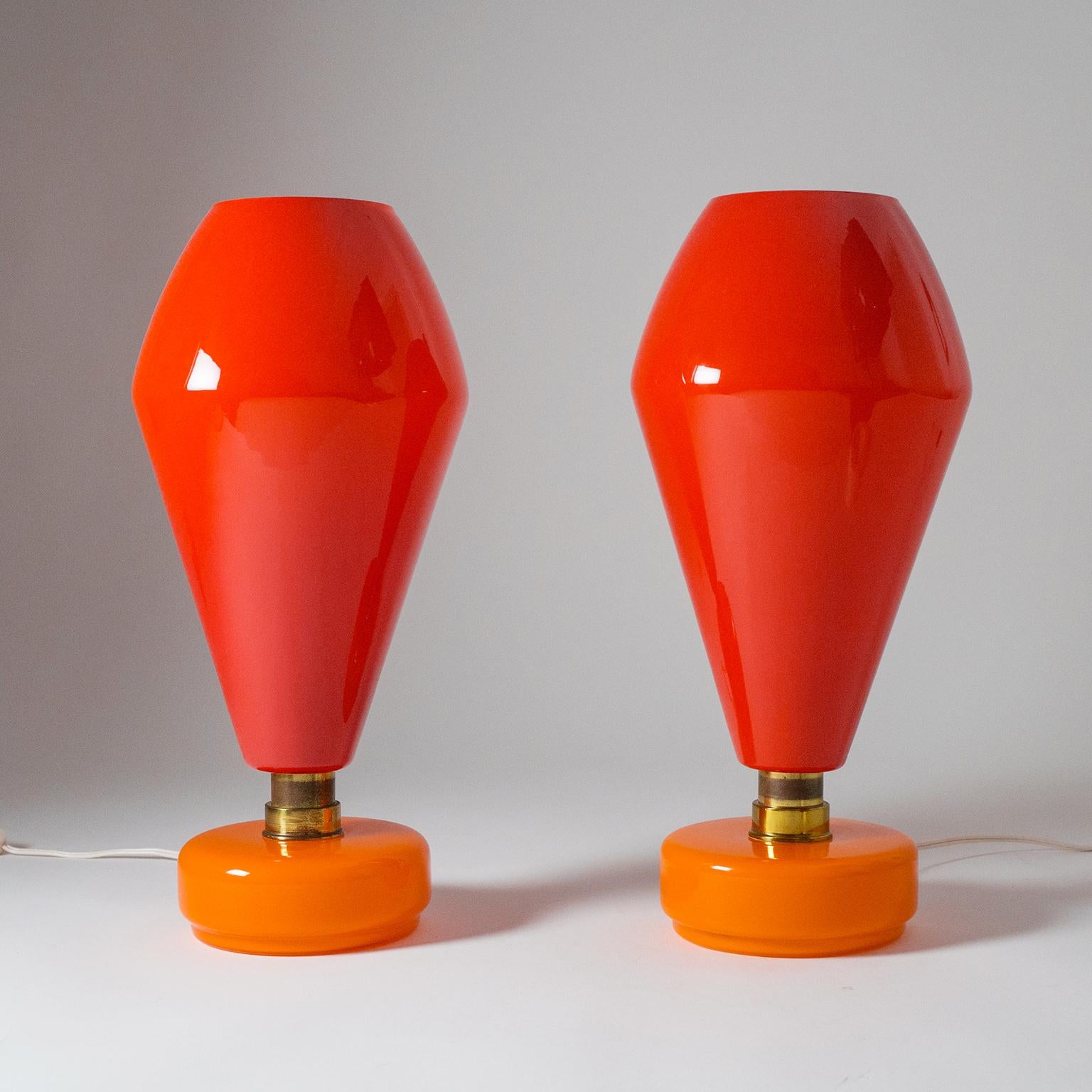 Very unique pair of large Murano glass table lamps by Vistosi. The strong color scheme and bold shape give these an organic pop art character which is amplified by their handblown nature. The large red shades are cased white on the inside and create