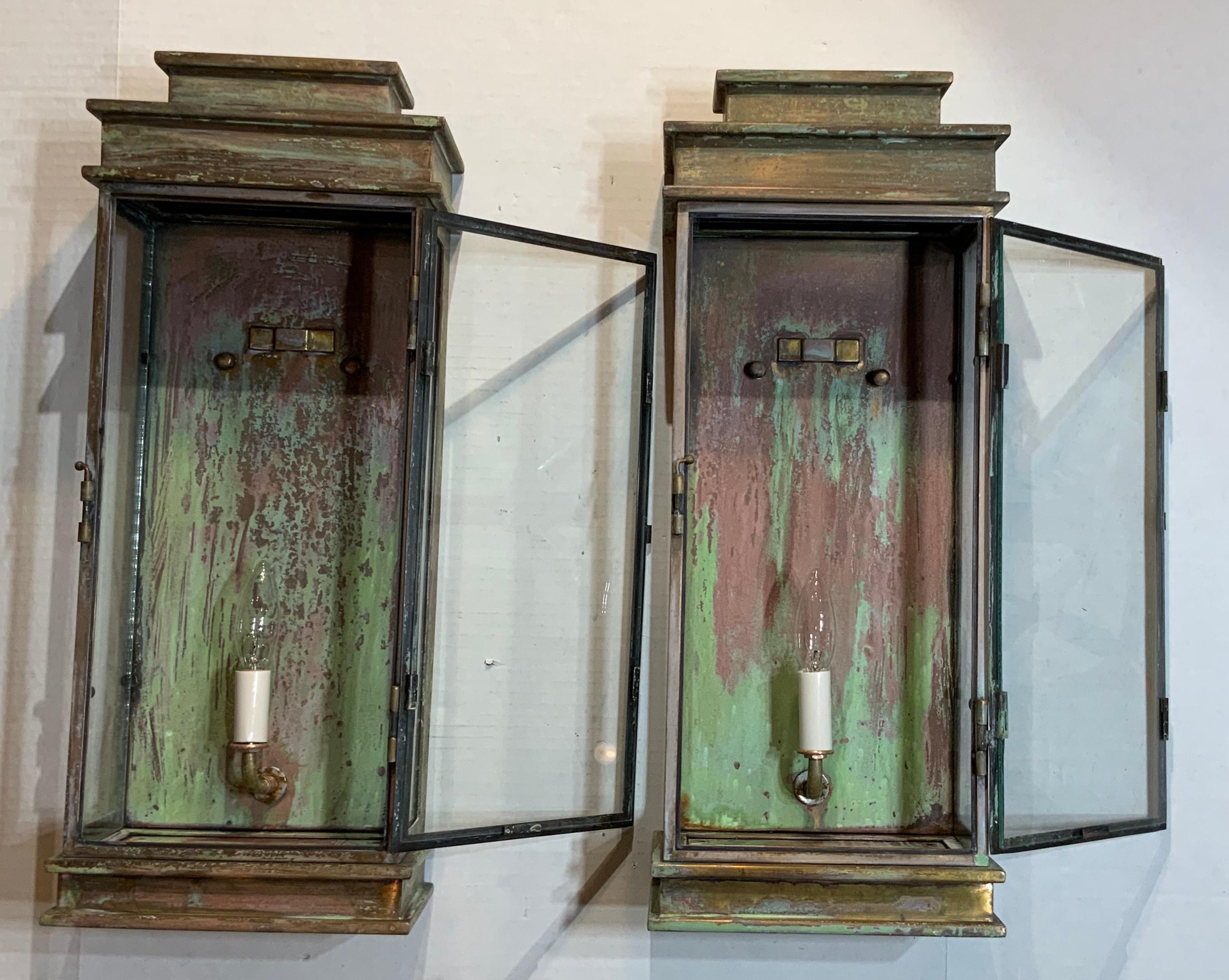 Pair of elegant wall hanging lanterns made of solid brass, beautiful weathered patina with one 60/watt light each. Suitable for wet locations. This pair will look great also as indoor sconces very decorative pair.